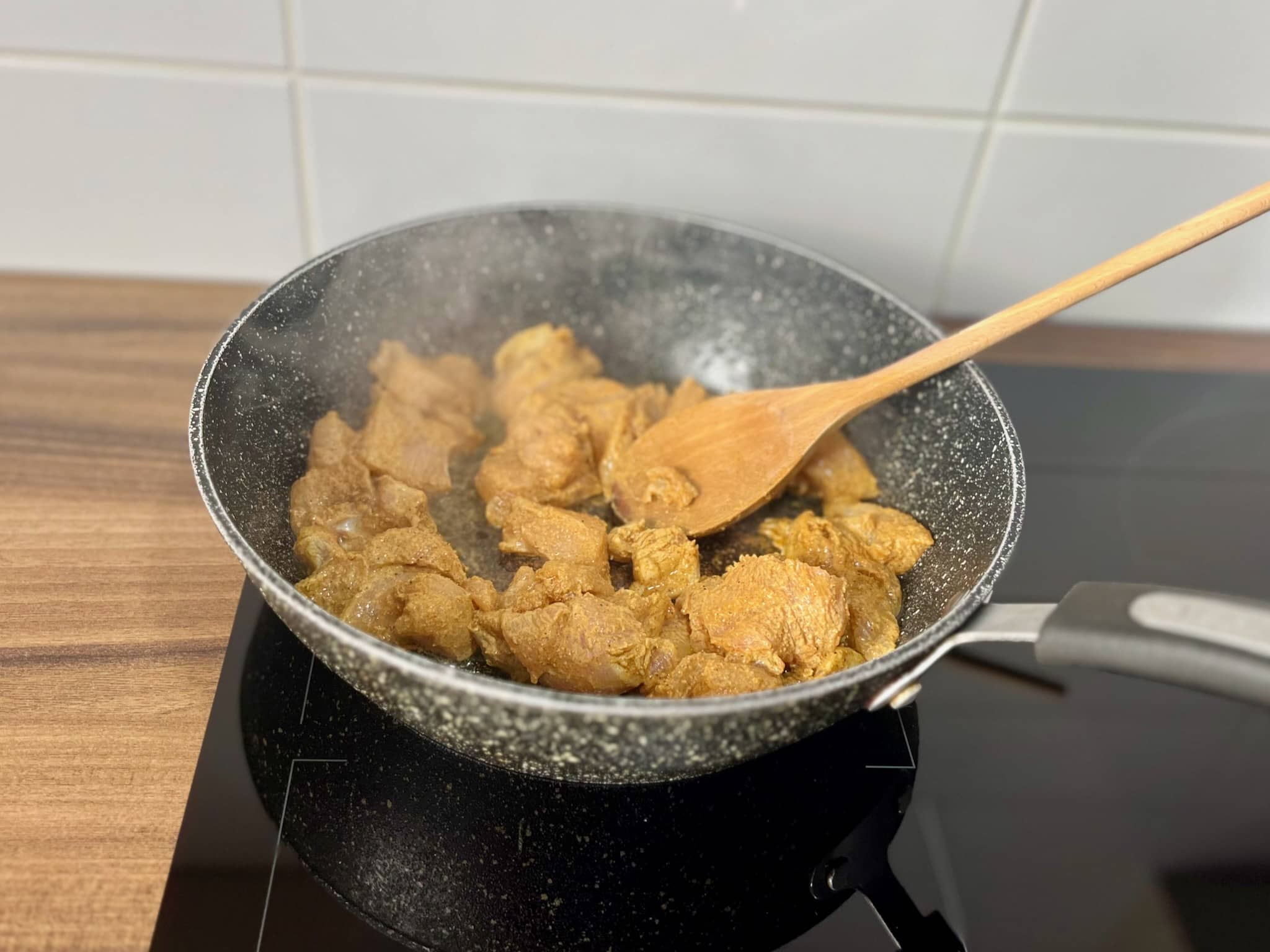 Cooking marinated chicken in a frying pan
