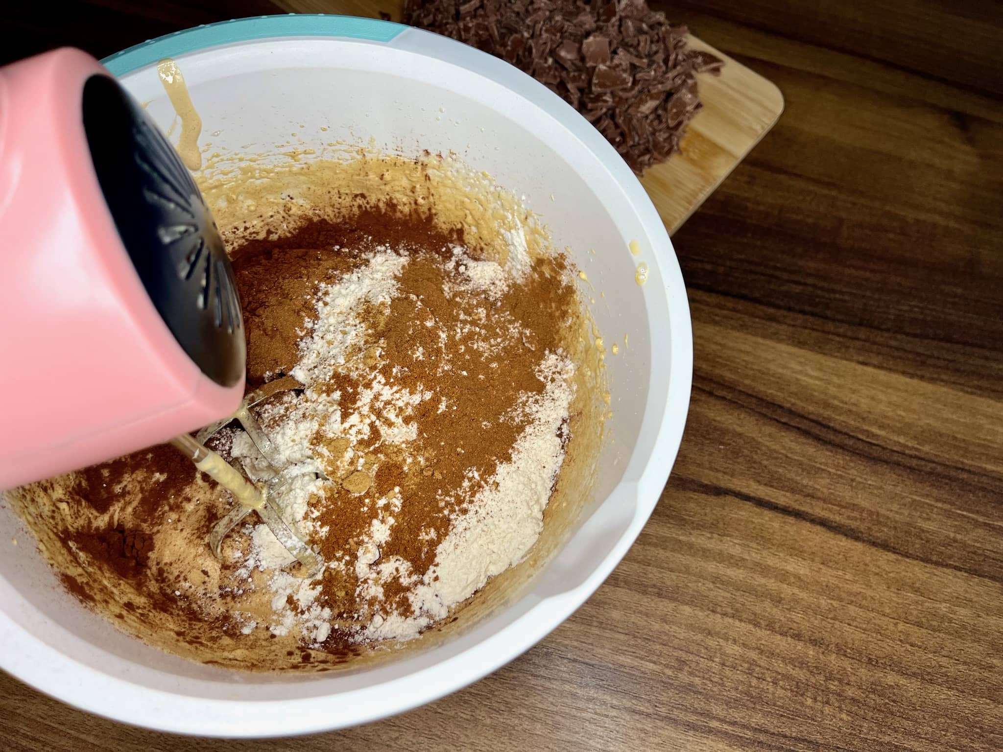 Gently mixing dry ingredients into the egg batter in a mixing bowl
