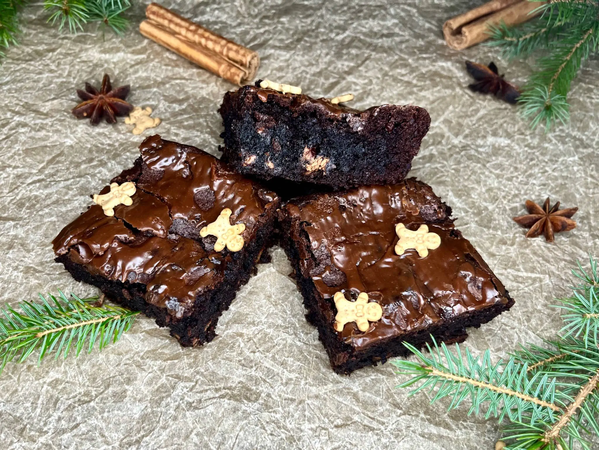 Trzy świeże kawałki piernikowego brownie na papierze do pieczenia, gotowe do zjedzenia