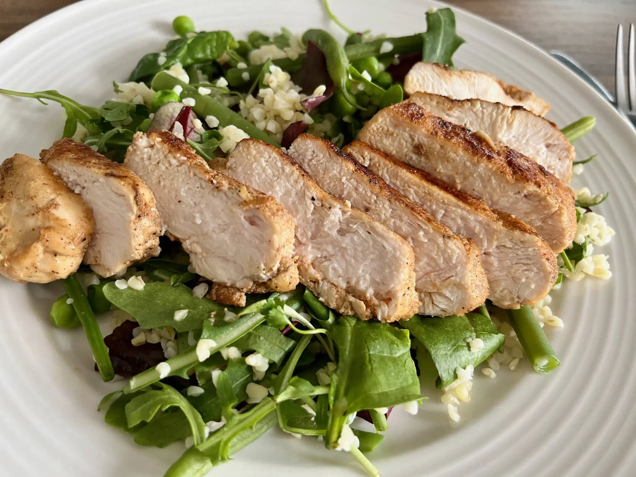 Green Bulgur Salad on a plate with Fried Chicken Breasts on top