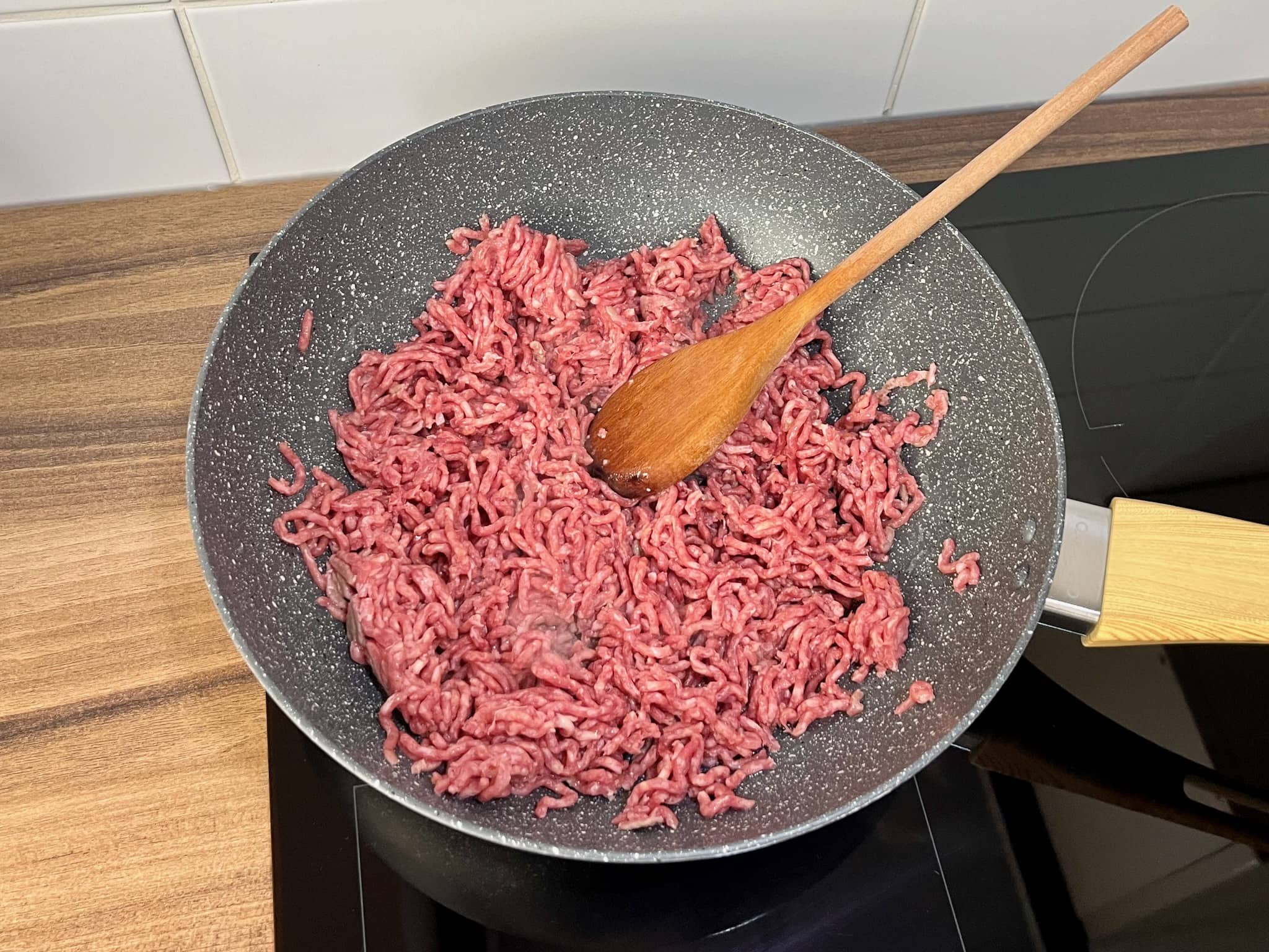 Ground beef is cooking in a frying pan