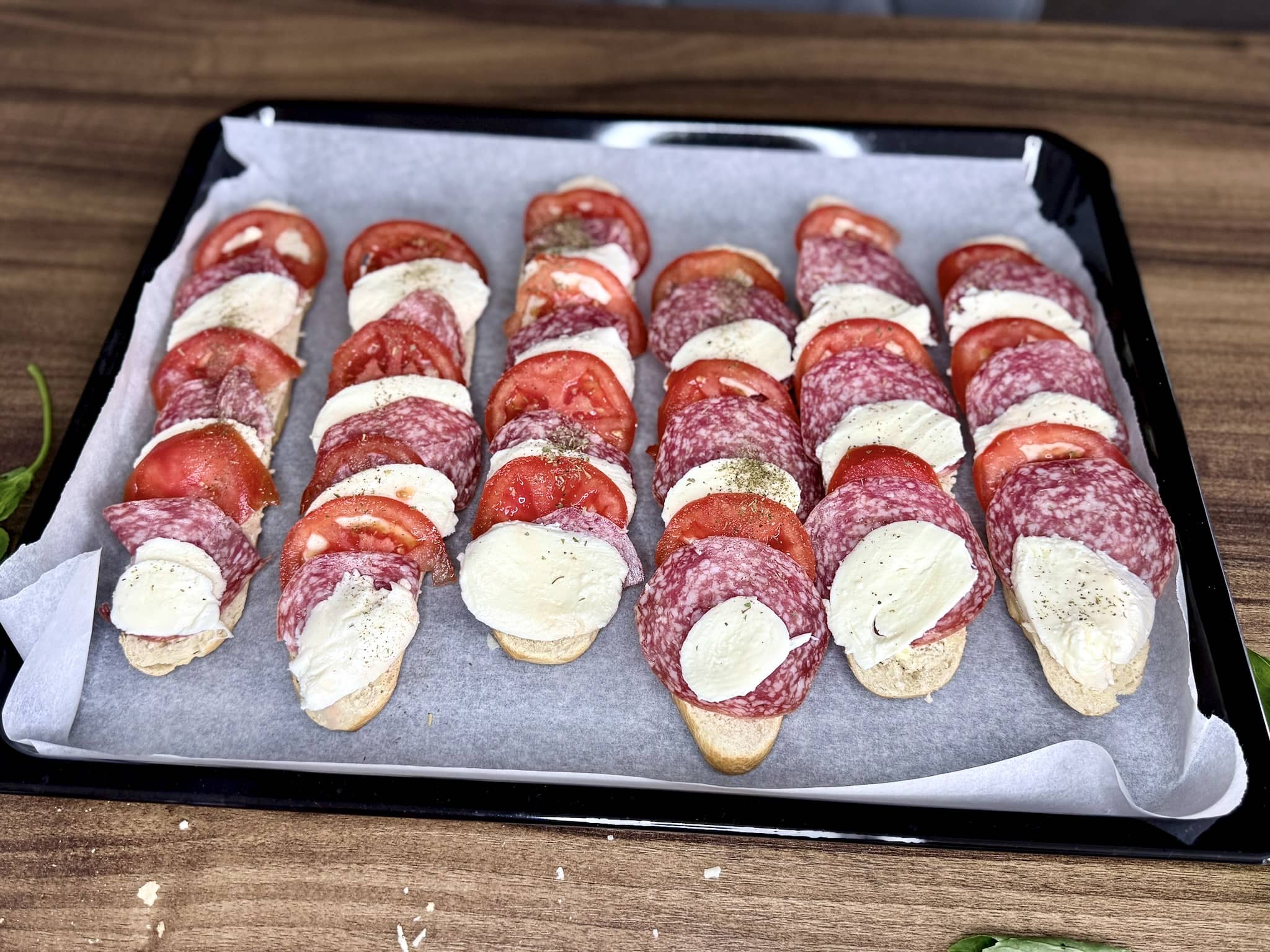Sandwiches neatly lined on a baking tray before being put into the oven
