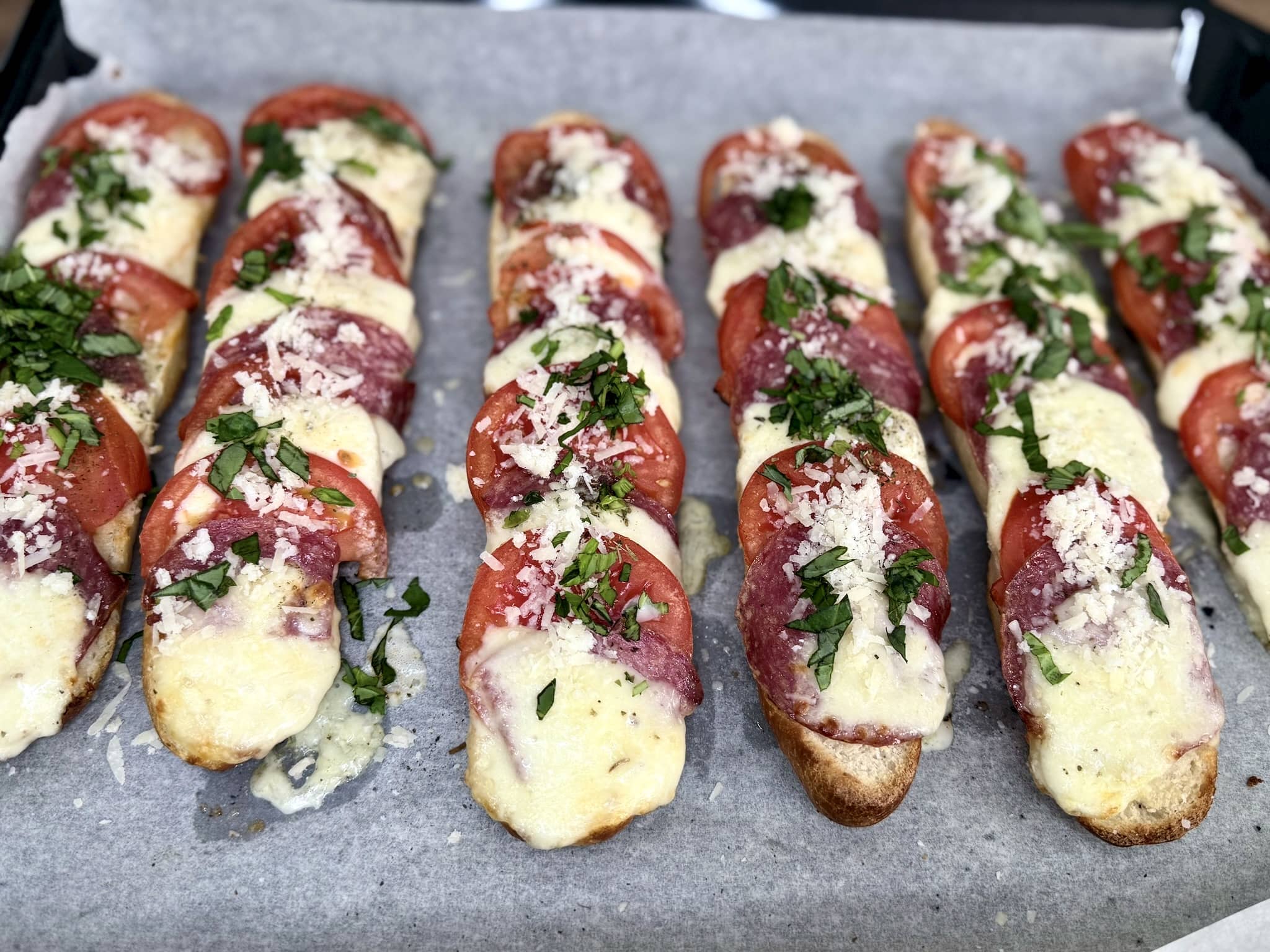 Sandwiches sprinkled with fresh basil and Parmesan