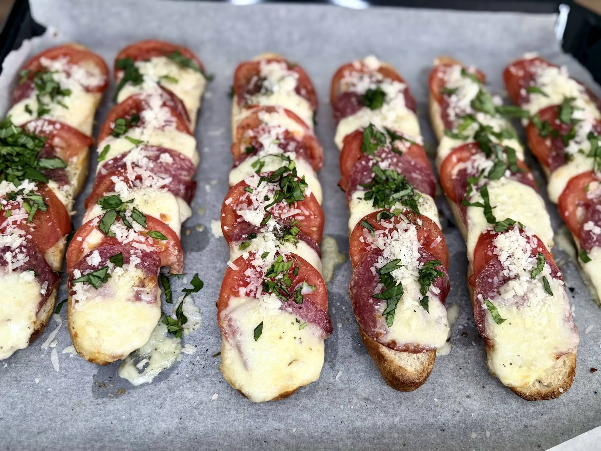 Zapiekanki posypane świeżą bazylią i parmezanem