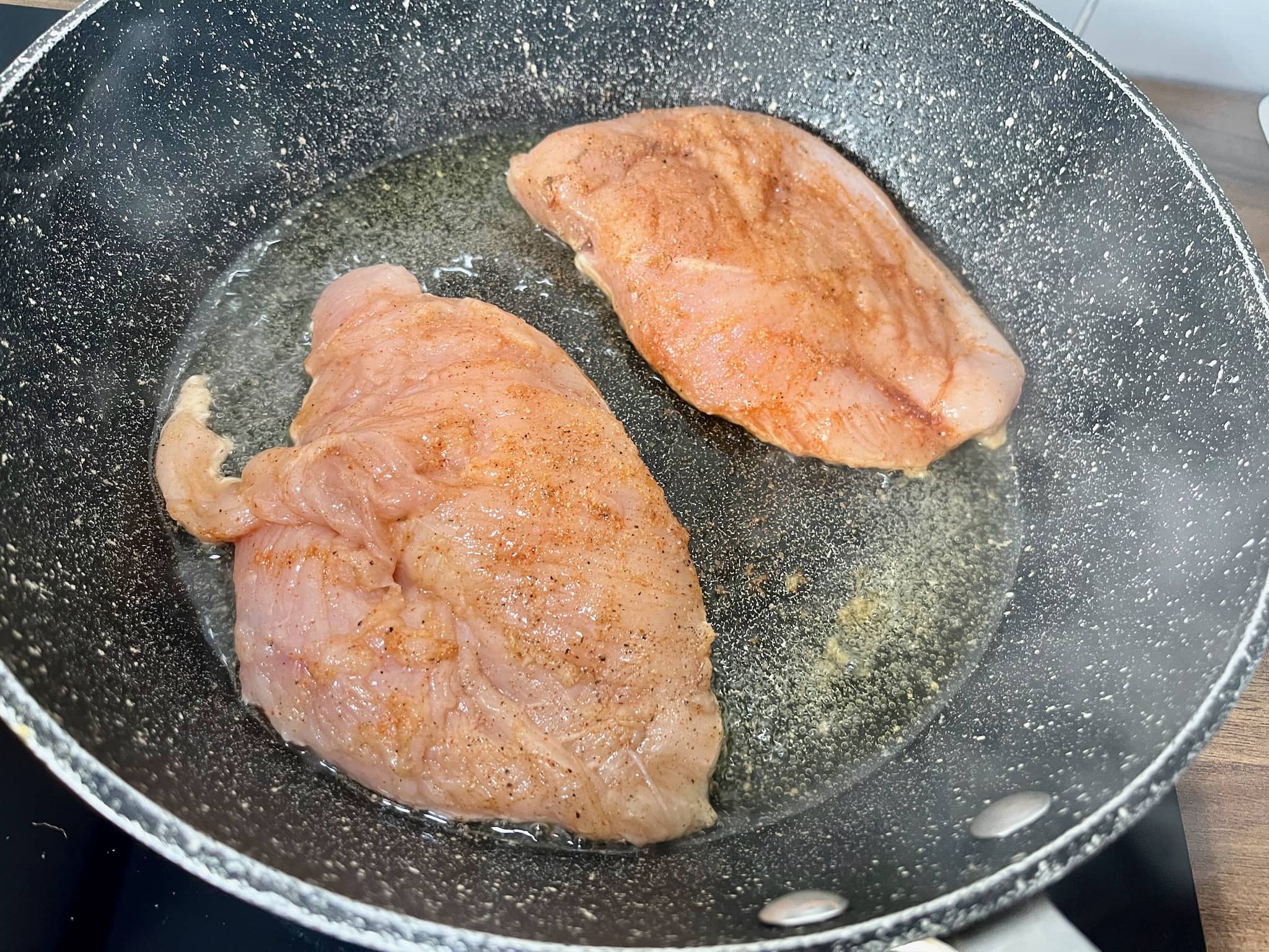 Chicken breasts seasoned with paprika, garlic and black pepper fried in a pan