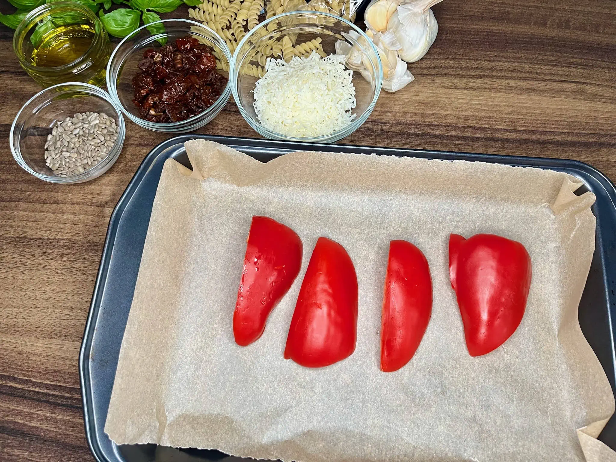 Red bell pepper, cut and placed on a baking tray, with other ingredients on the side