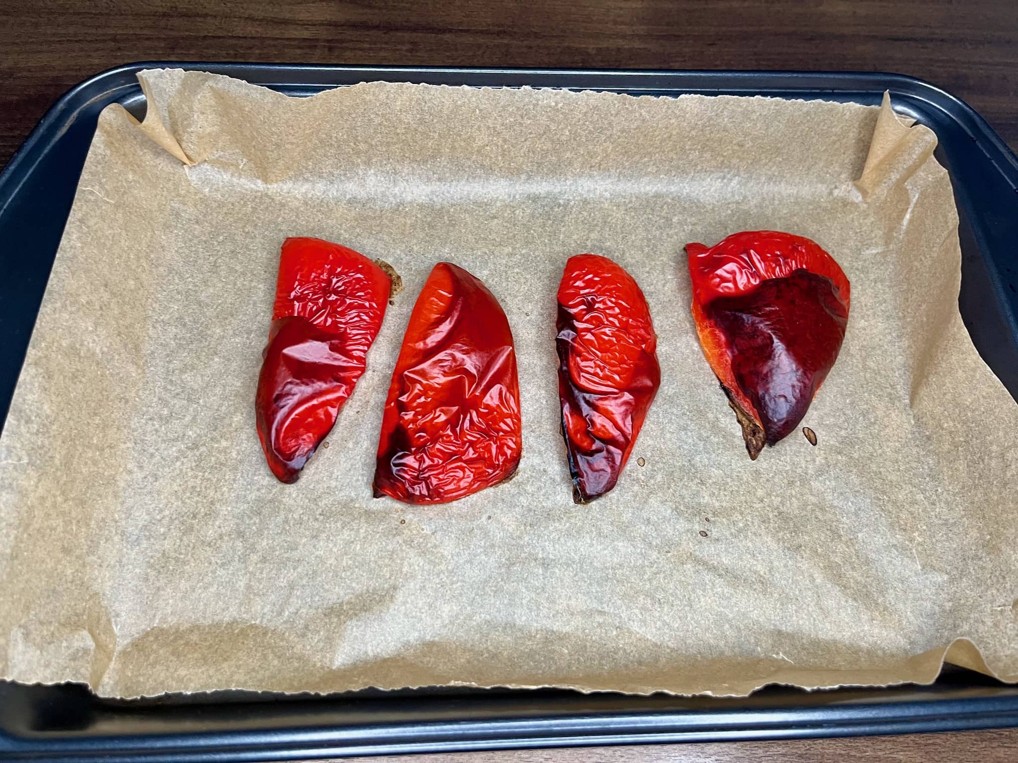 Red bell pepper, cut and placed on a baking tray, with other ingredients on the side