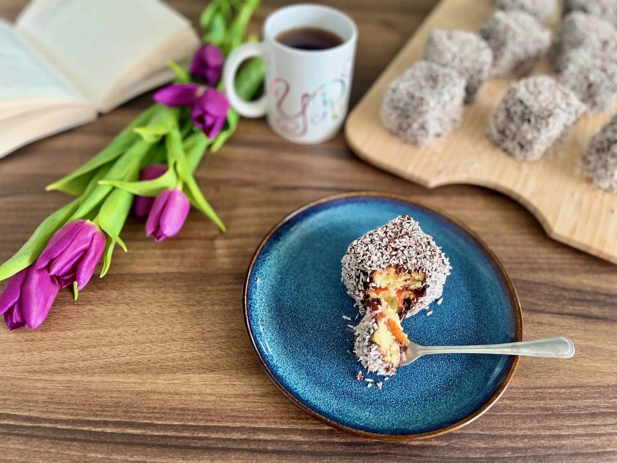 Lamington na talerzu, a obok reszta kwadratów na desce do krojenia