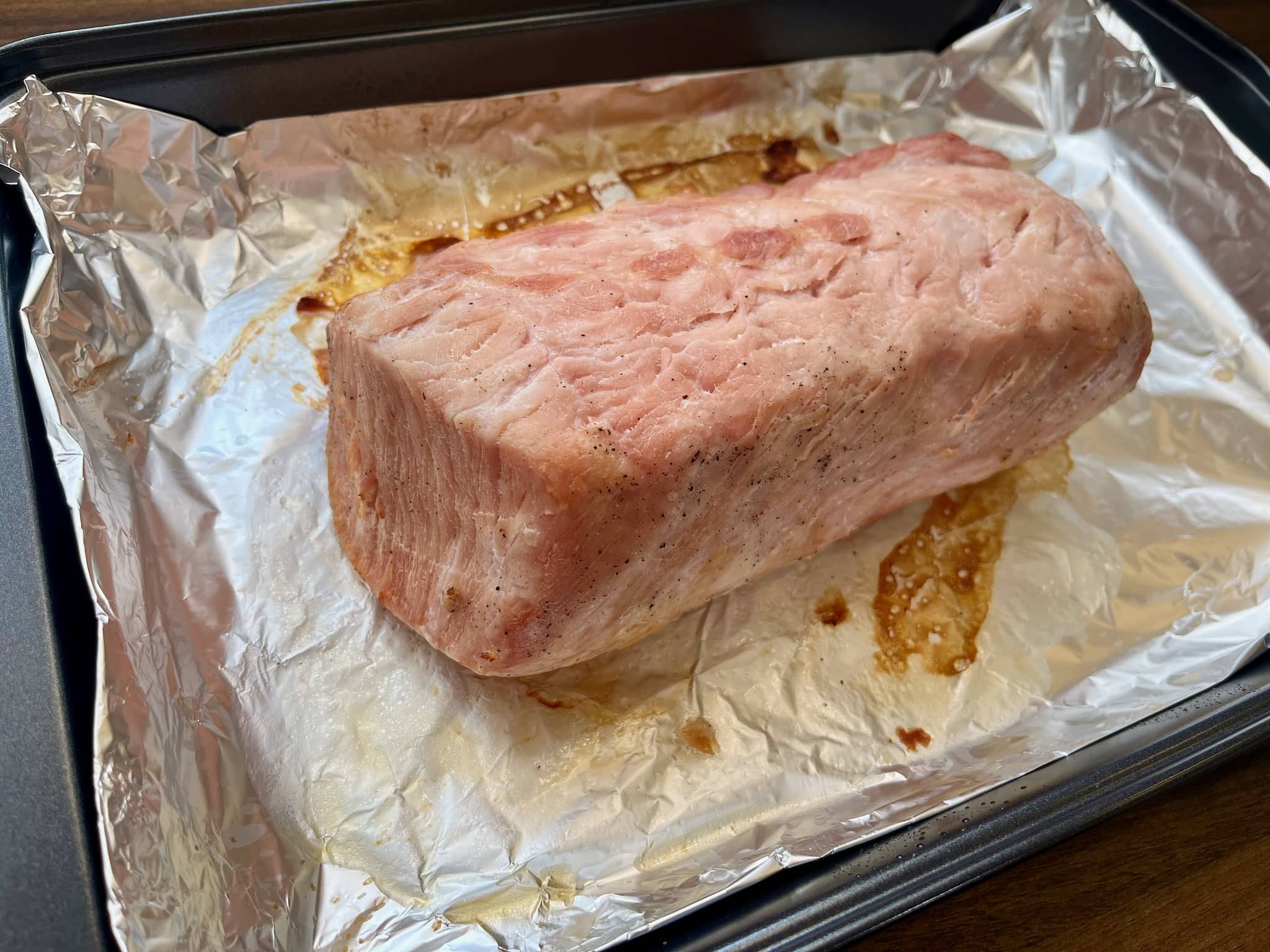 Marinated pork loin on a lined baking tray after final baking