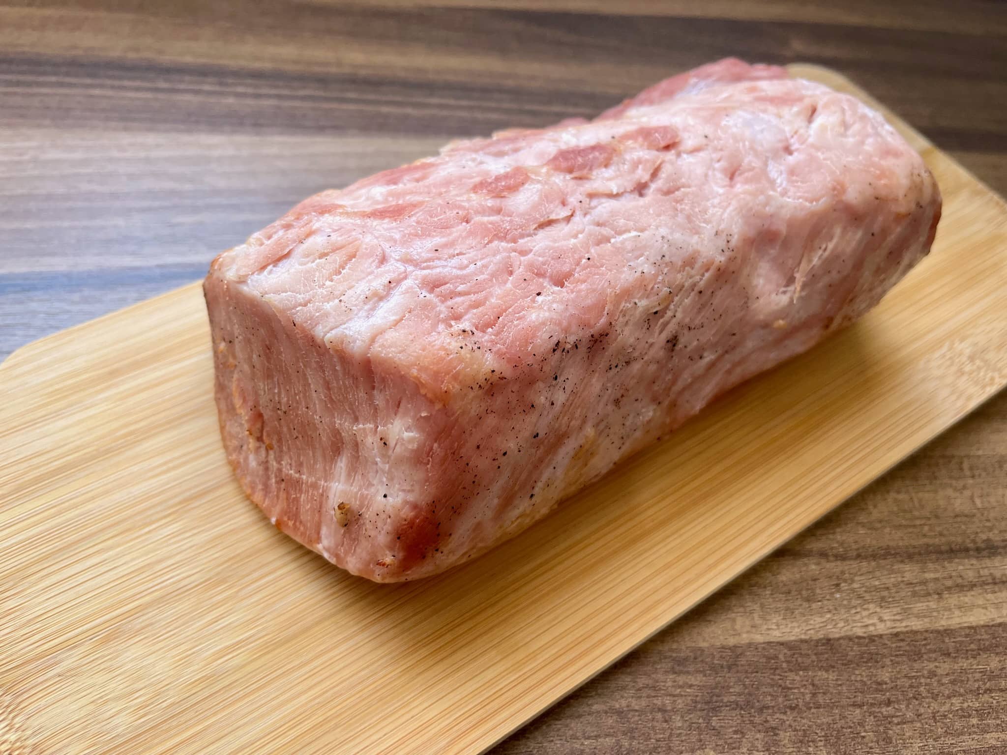 Baked marinated pork loin resting on a chopping board