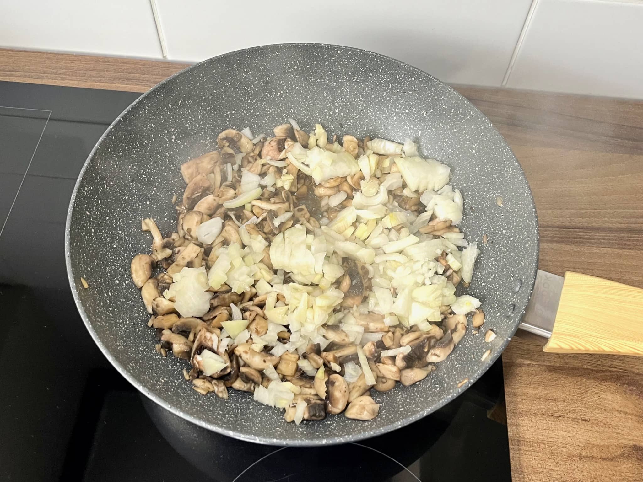 Mushrooms and onion frying in a pan