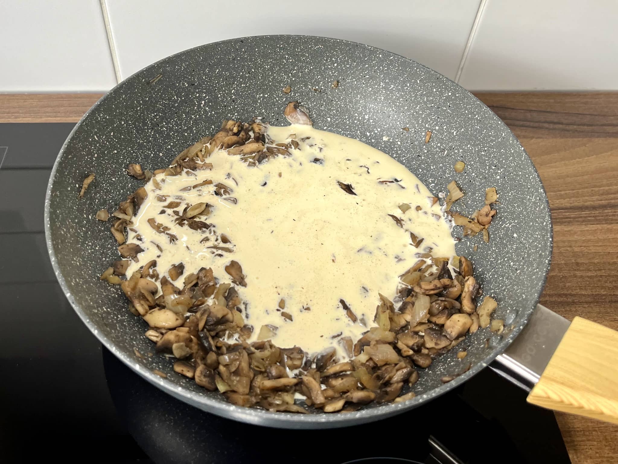 Mushrooms and onion in a pan with added double cream