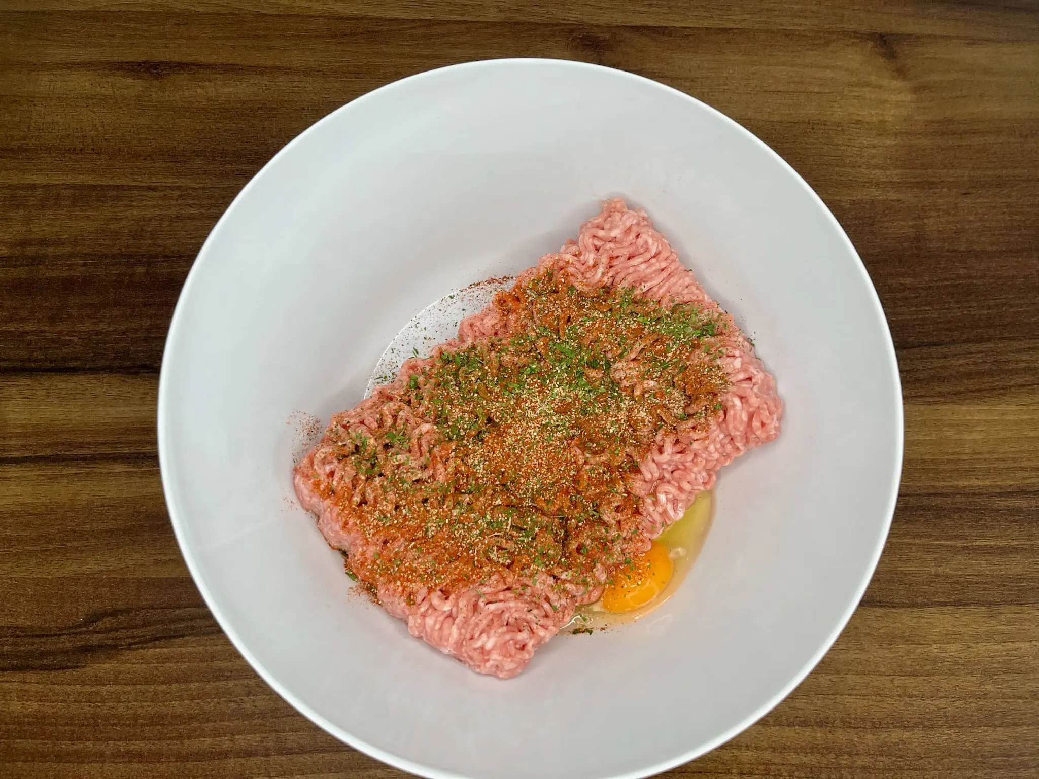 Mixing the pork mince in a bowl with other ingredients to make meatballs
