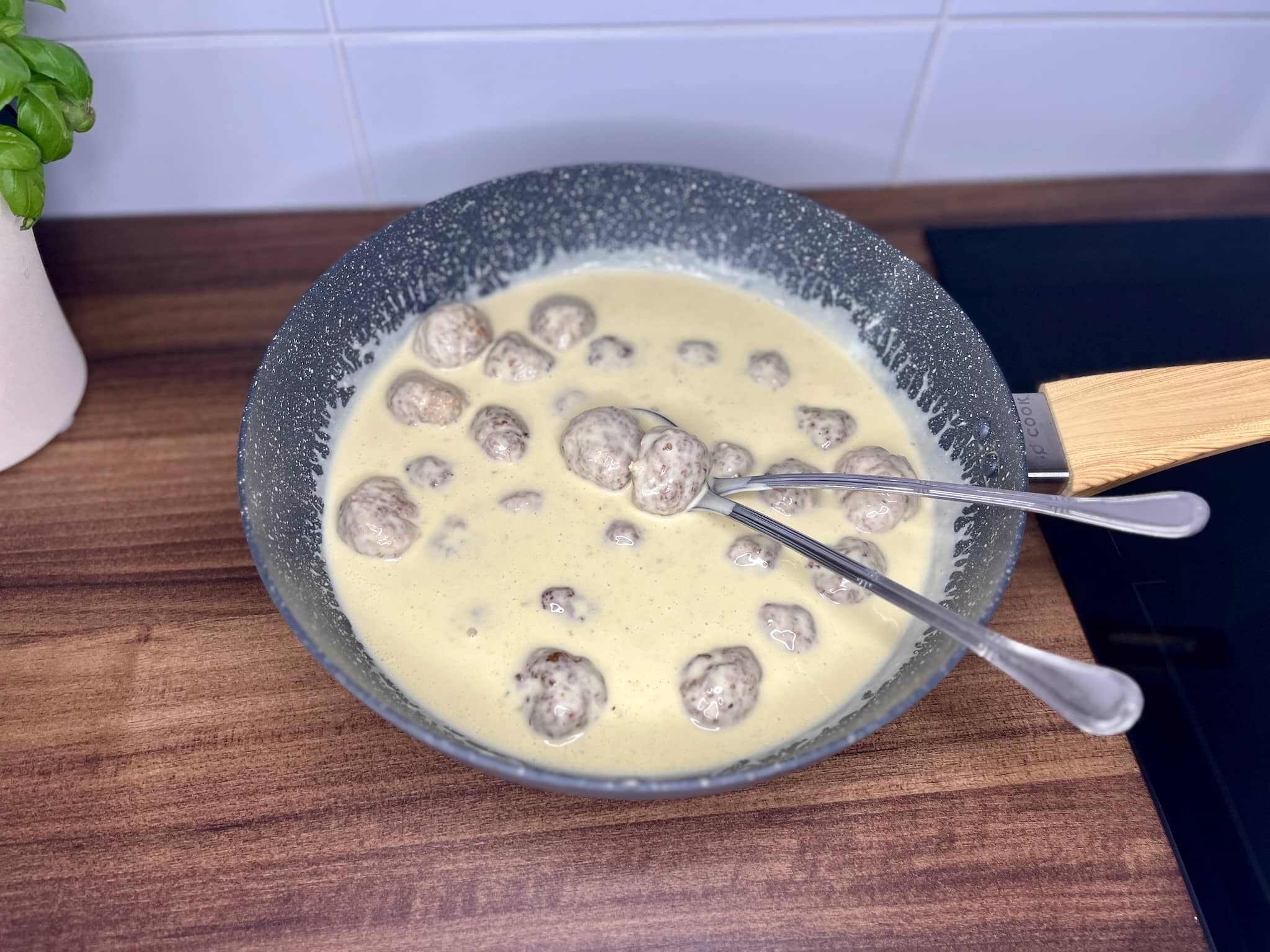 The baked meatballs are gently folded into the creamy sauce