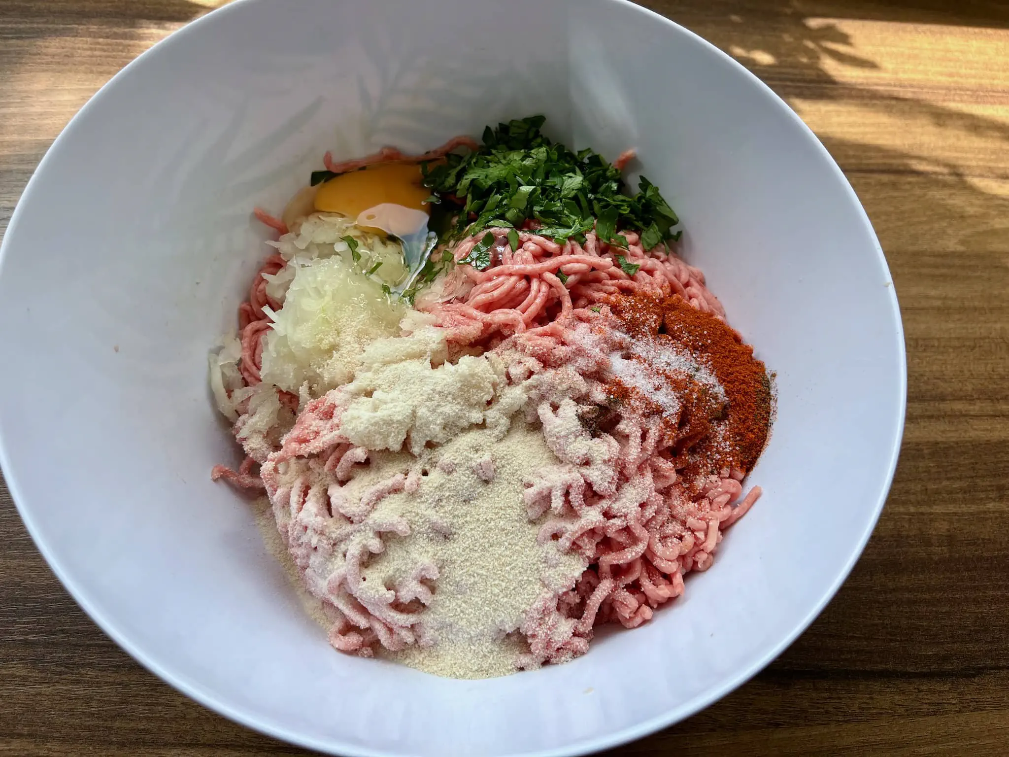 All the ingredients in a bowl ready to make a mix for meatballs