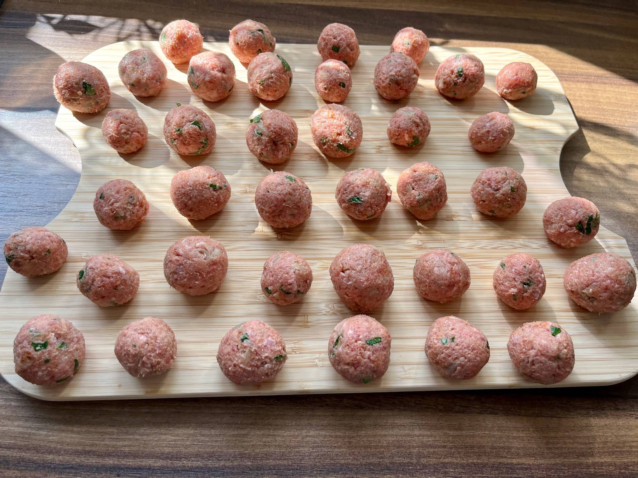 Meatballs balls on a chopping board before frying