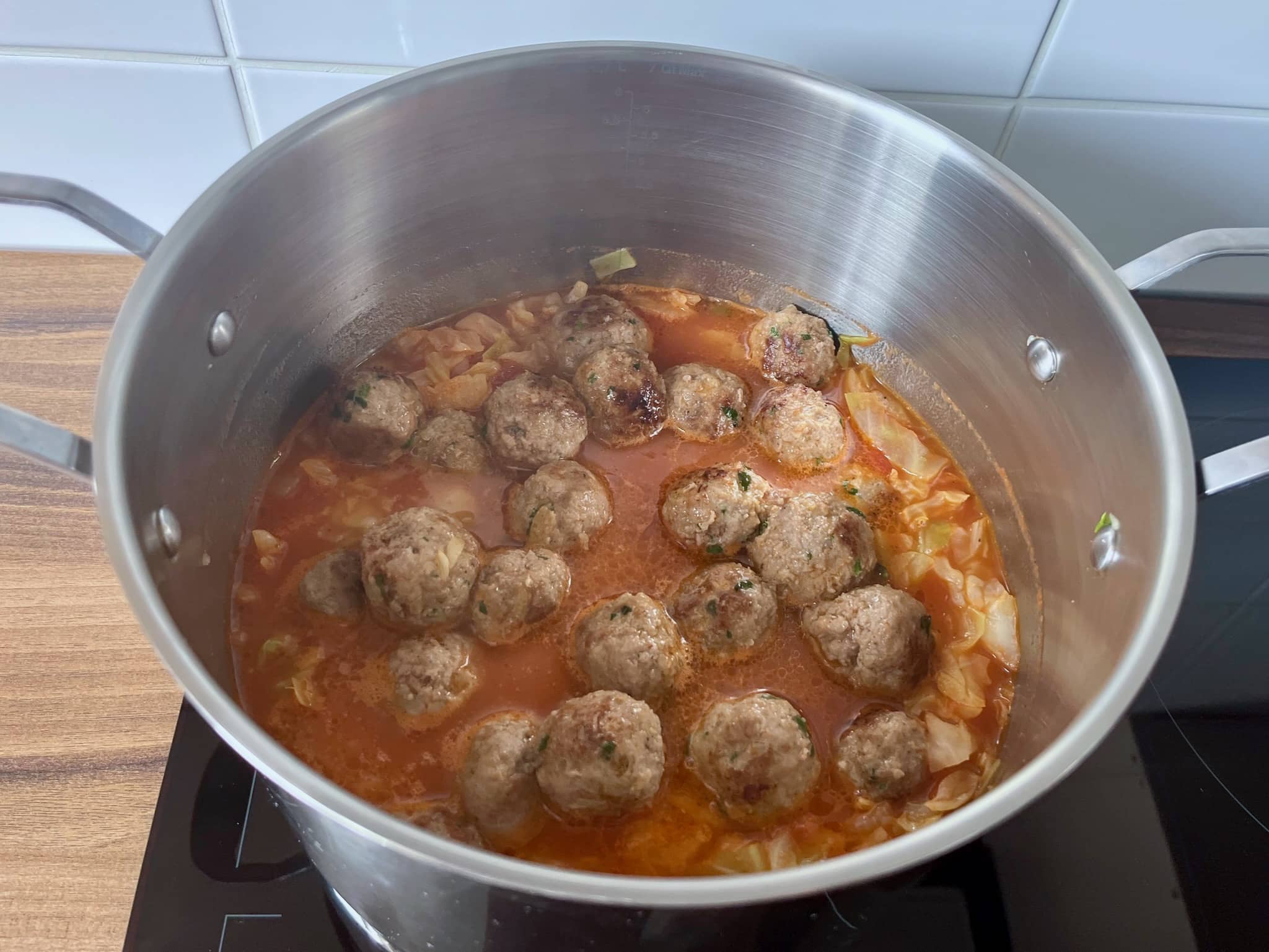 Cabbage and meatballs cooking in a pan