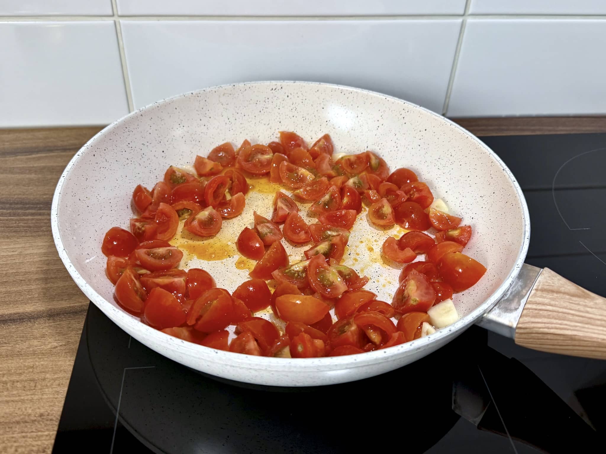 Pomidorki cherry i czosnek smażą się na patelni