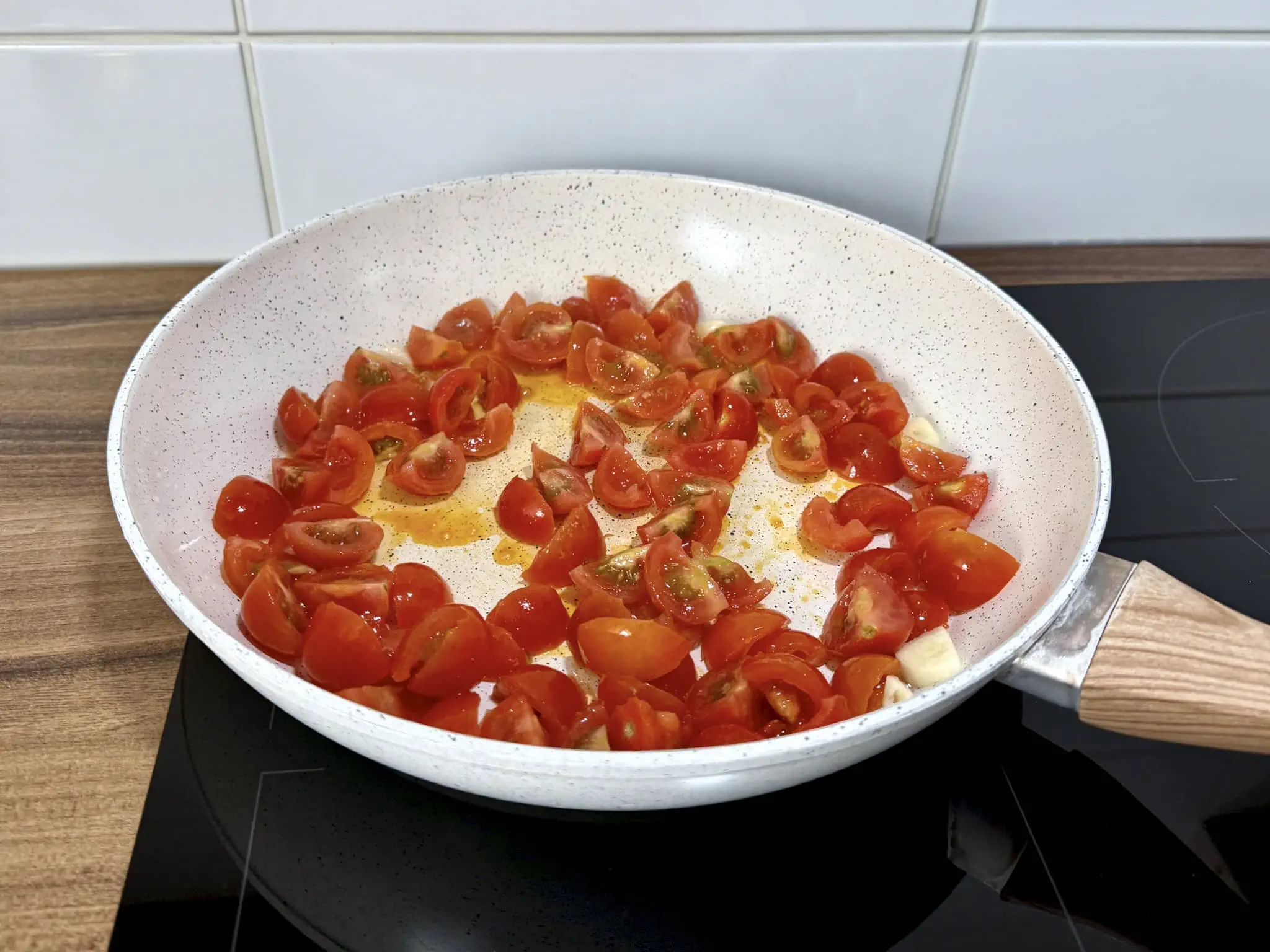 Pomidorki cherry i czosnek smażą się na patelni