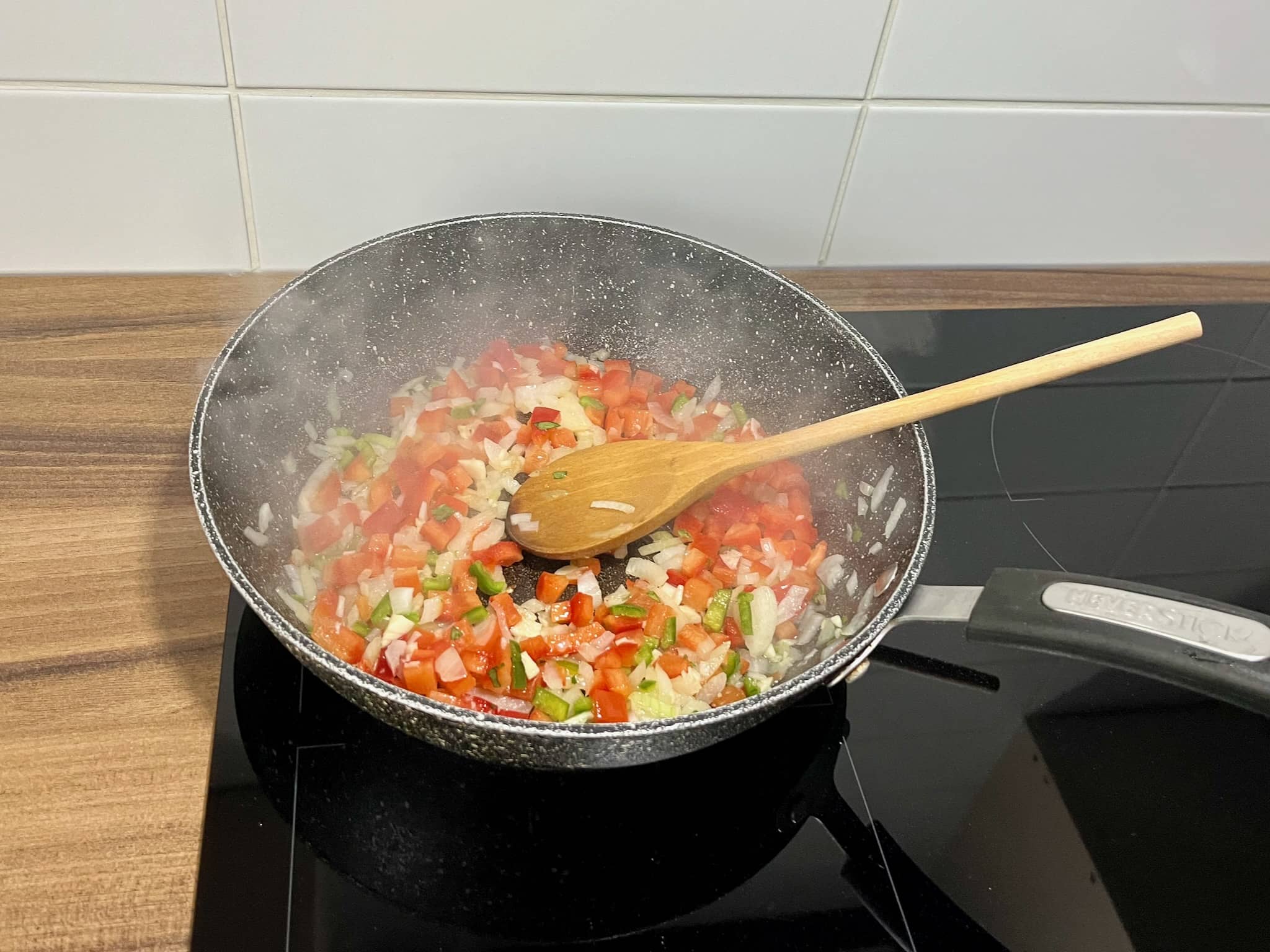 Peppers, onion and garlic frying in a pan