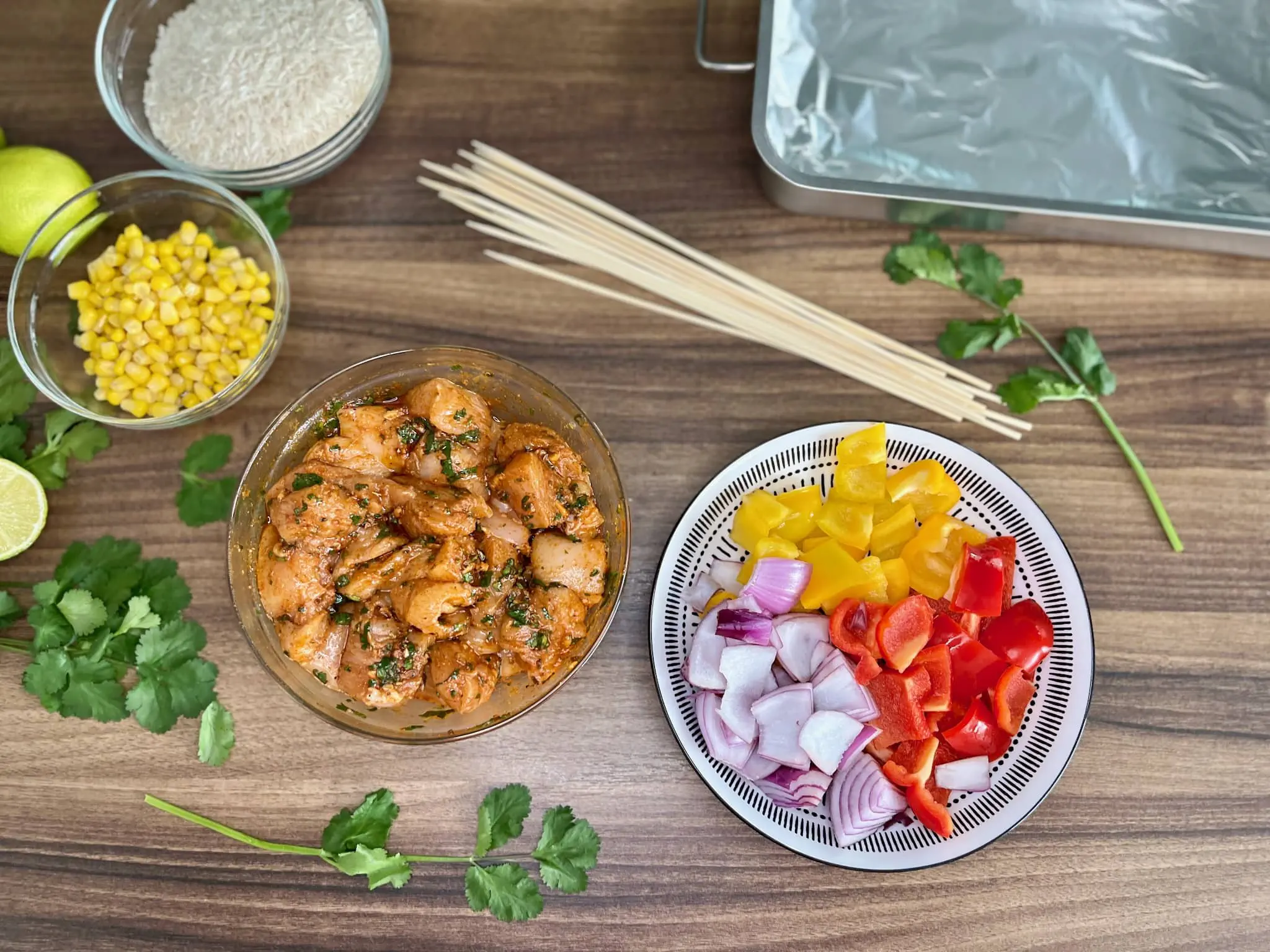 Marinated chicken and colorful veggies, ready for skewers, on a table
