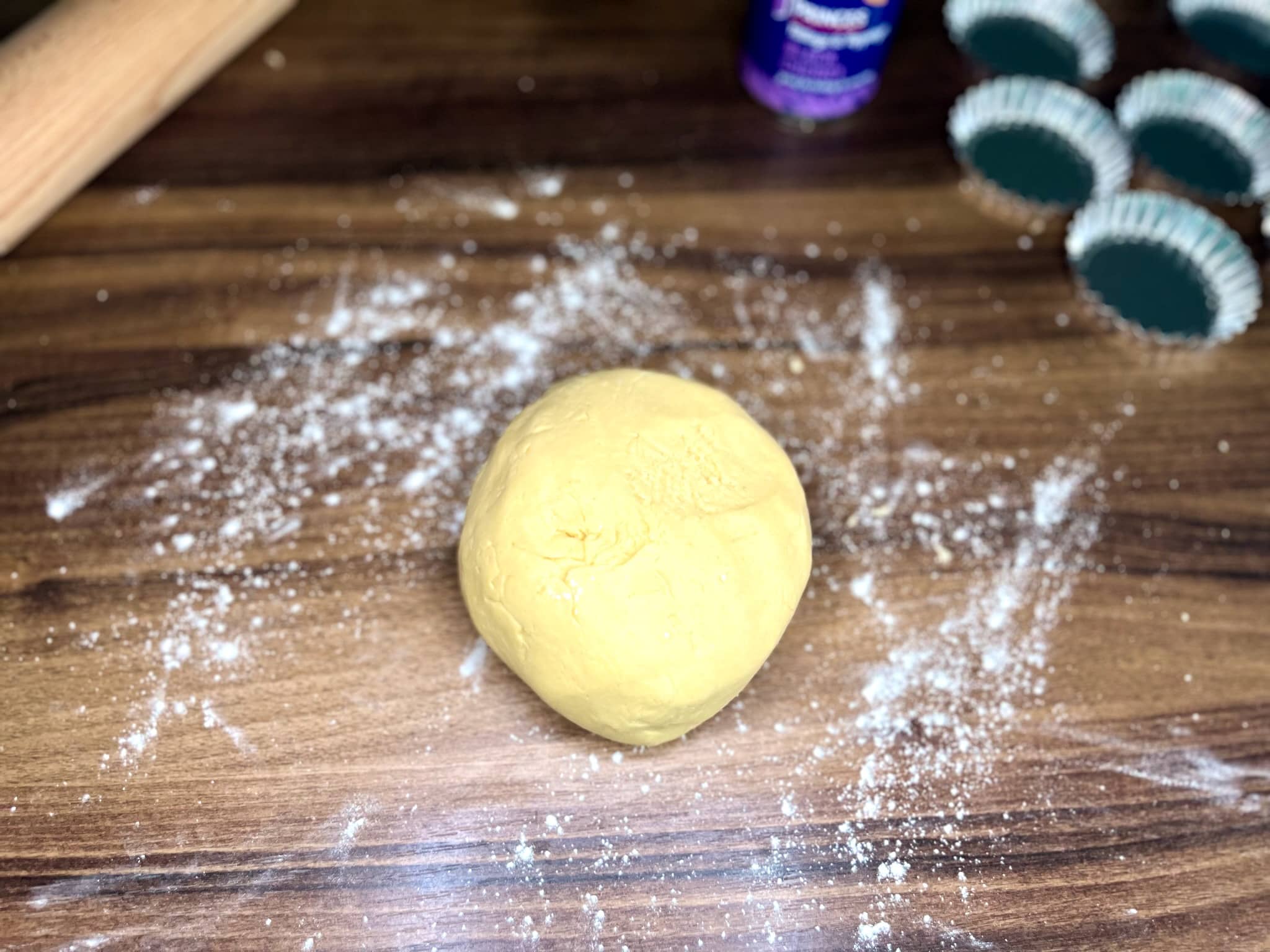 A ball of dough has been formed on the floured tabletop