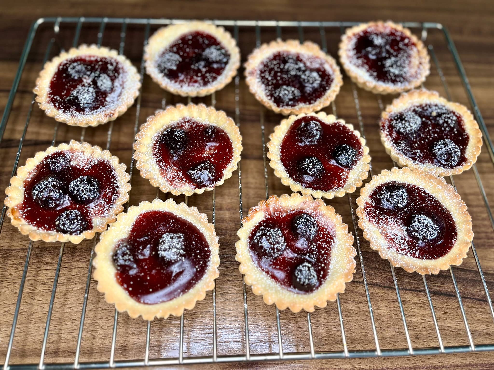 Mini Cherry Tarts, cooled and dusted with icing sugar, are ready to serve
