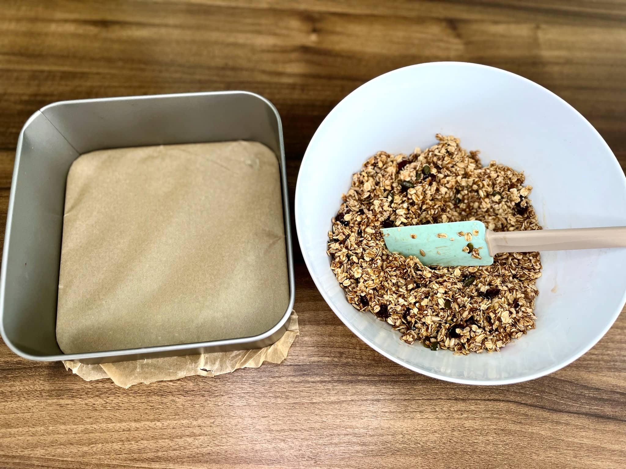 The muesli bar mixture is ready in a bowl, with the baking tray prepared