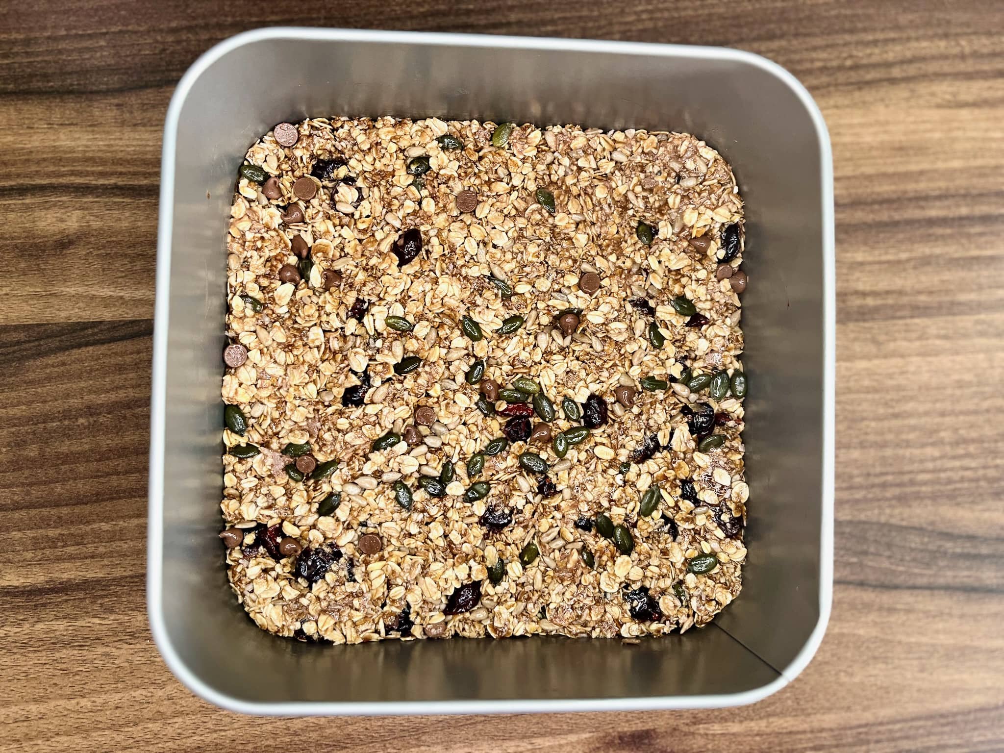 The muesli bar mixture is pressed into a tray