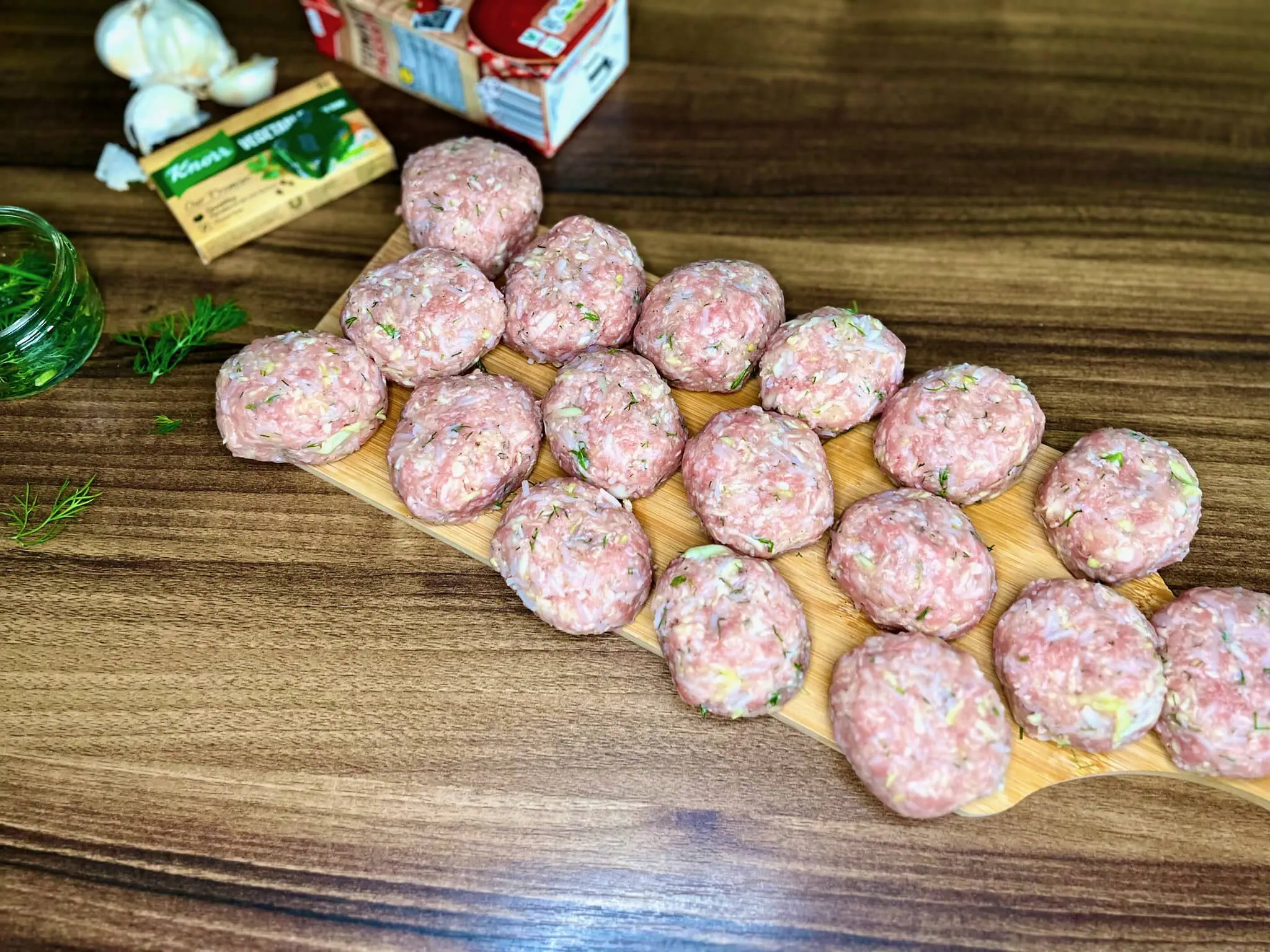 Uformowane owalne gołąbki na desce do krojenia, gotowe do smażenia