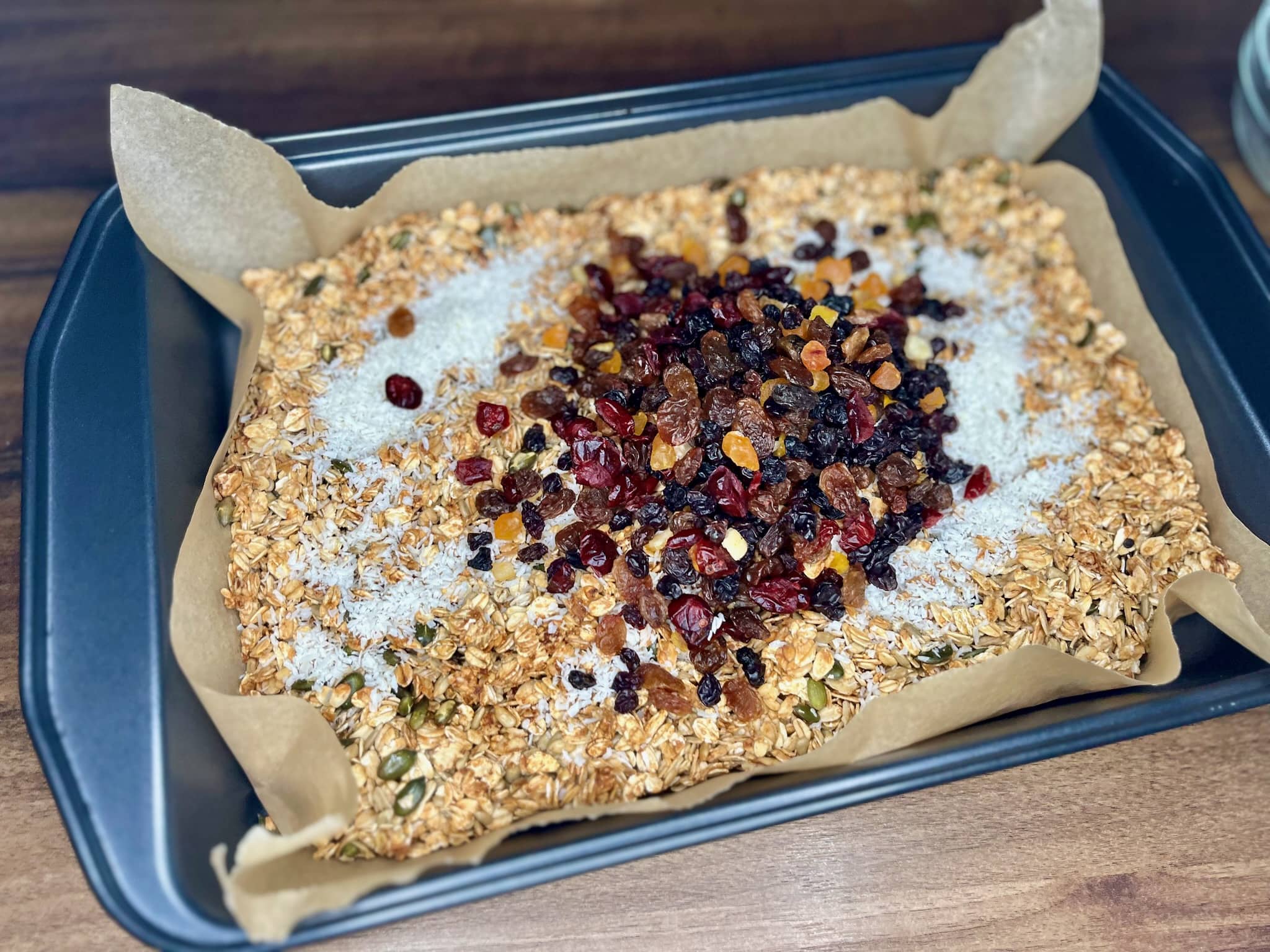 Baked oats-seeds mixture with dried mixed fruits and coconut on the top