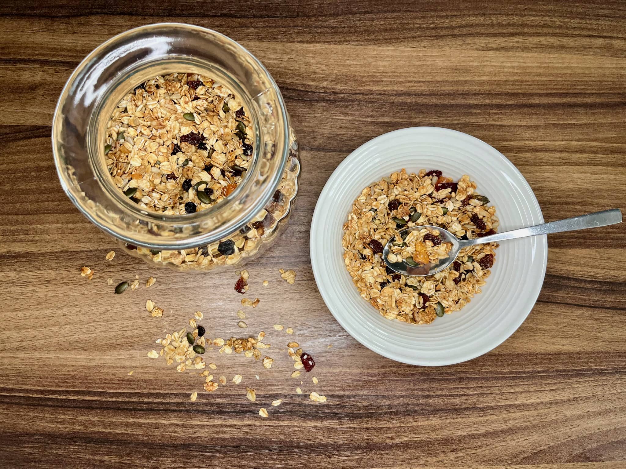 Nut-free homemade granola in a glass jar along with a portion on a plate