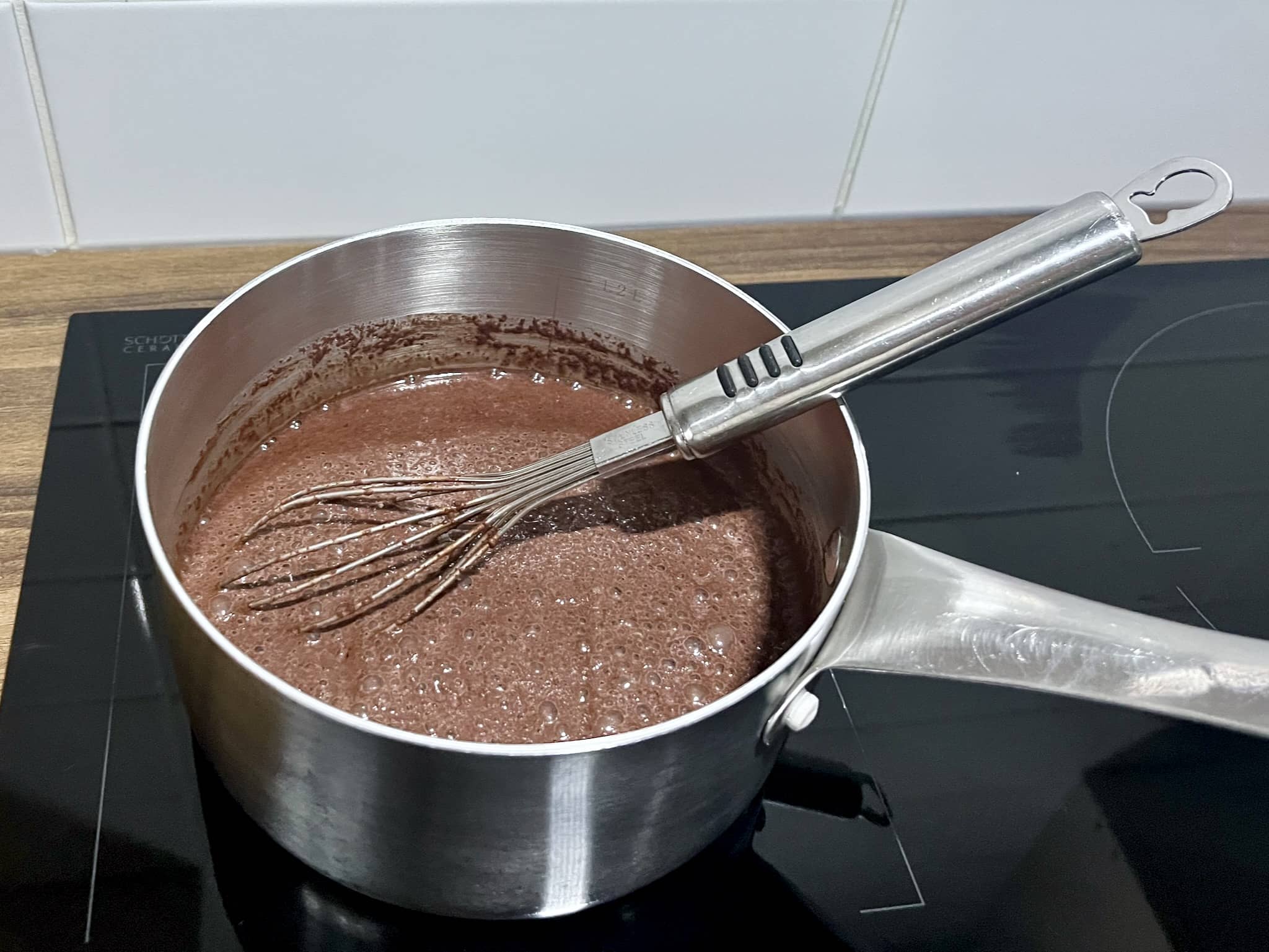 Saucepan with milk, sugar, cocoa powder, and chocolate chips