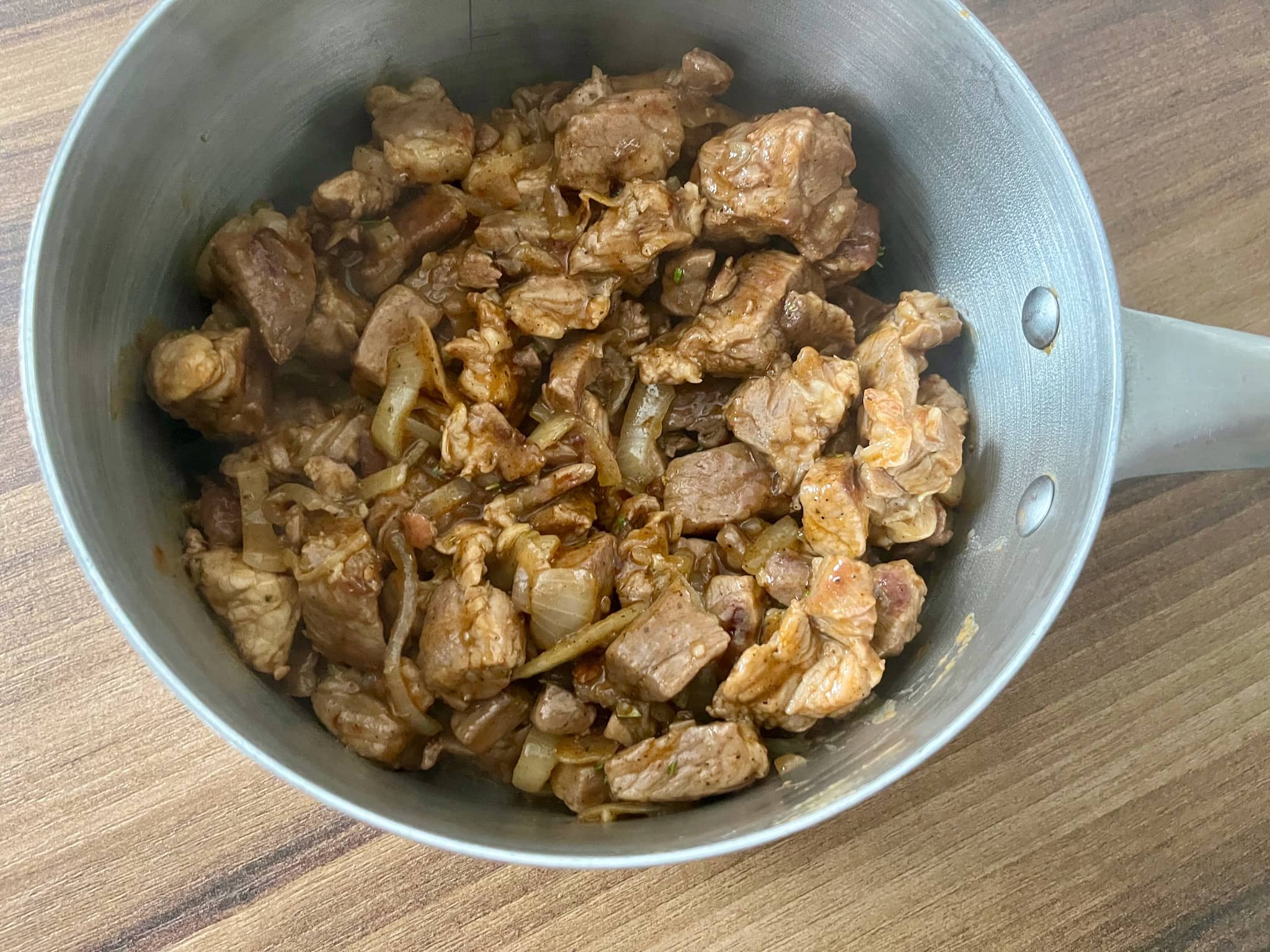 Cooked pork placed into a saucepan