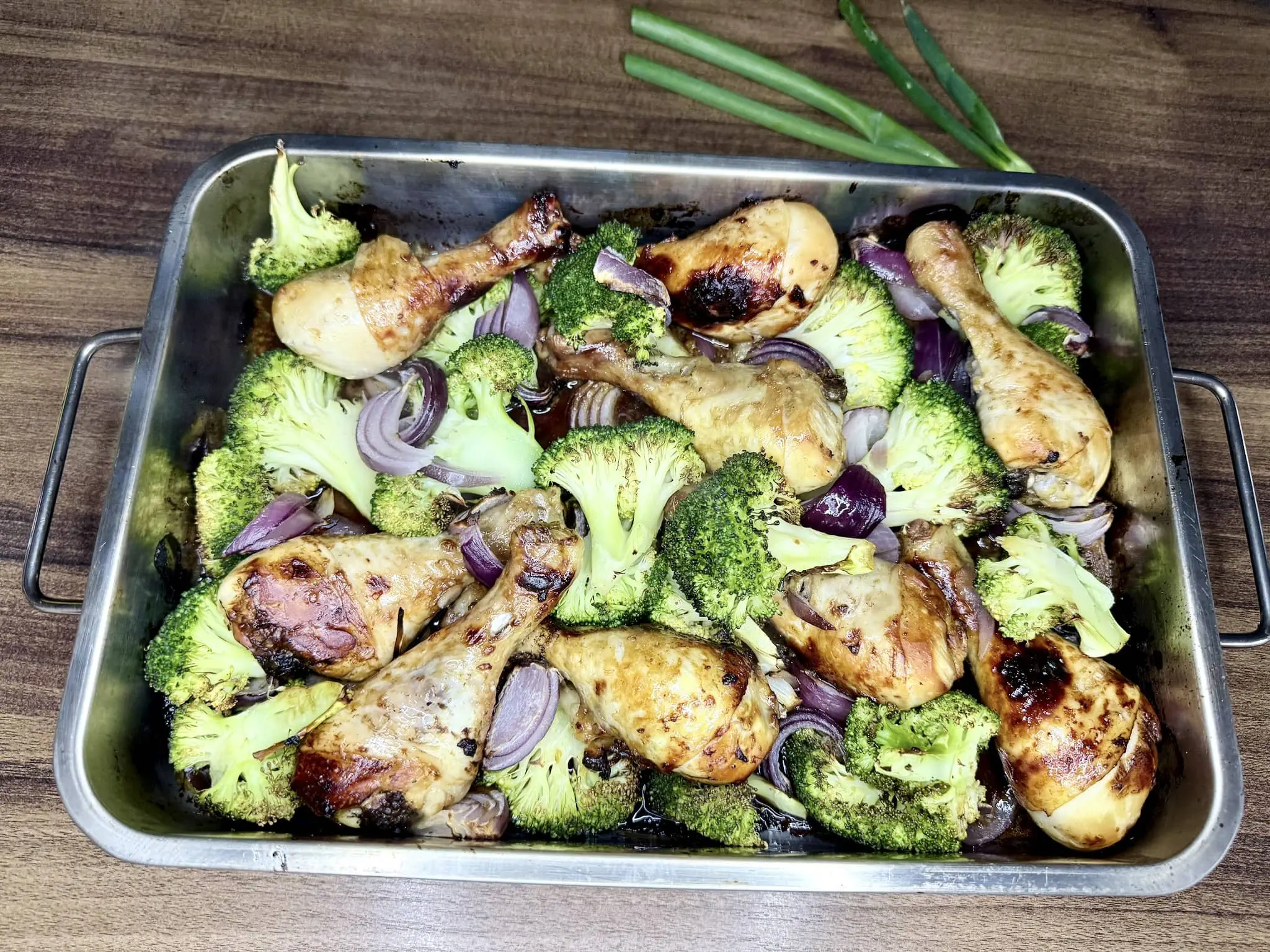 Oriental Spiced Chicken Drumsticks with vegetables taken out from the oven