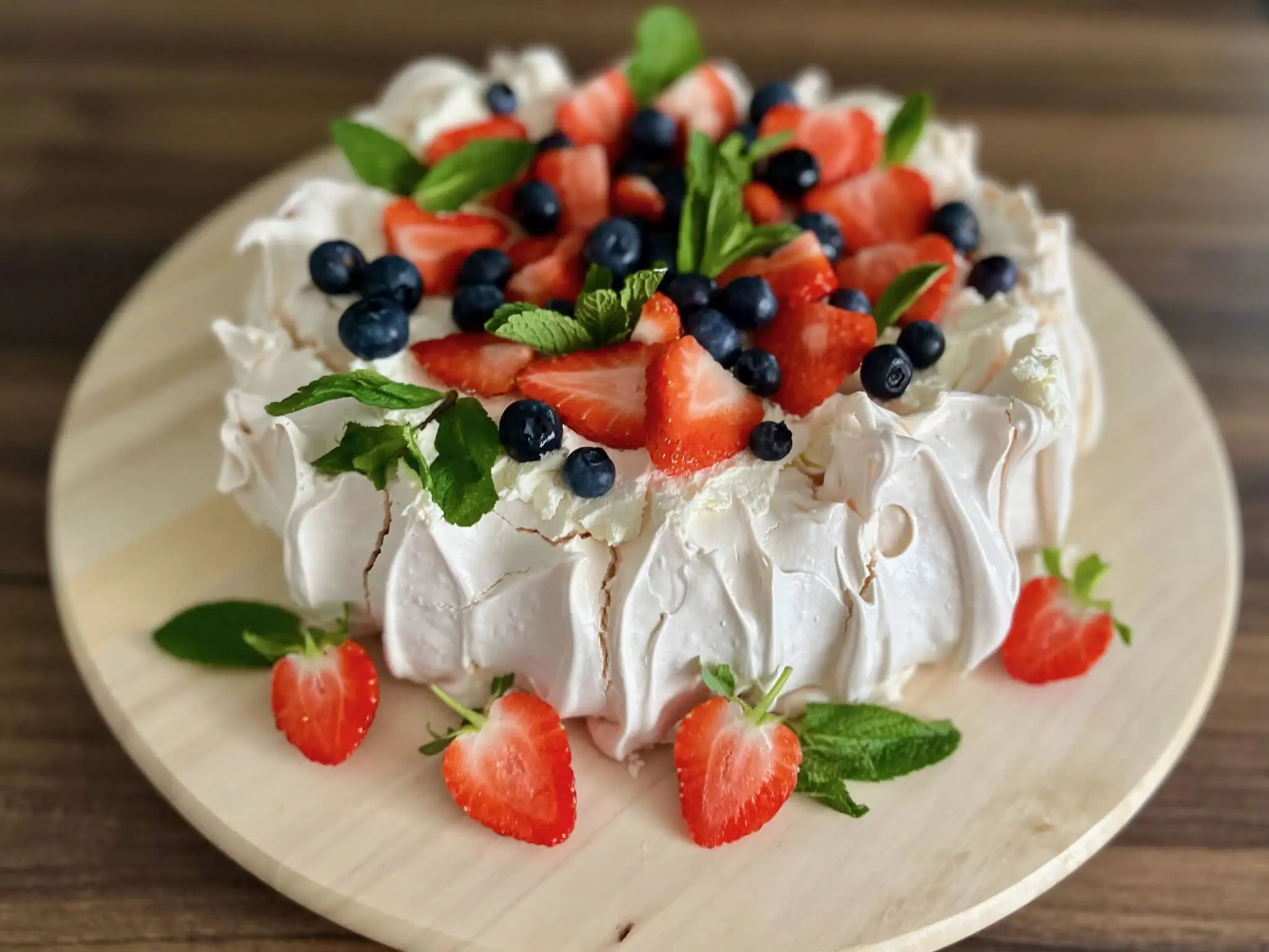 Gotowa Beza Pavlova udekorowany truskawkami, borówkami i miętą