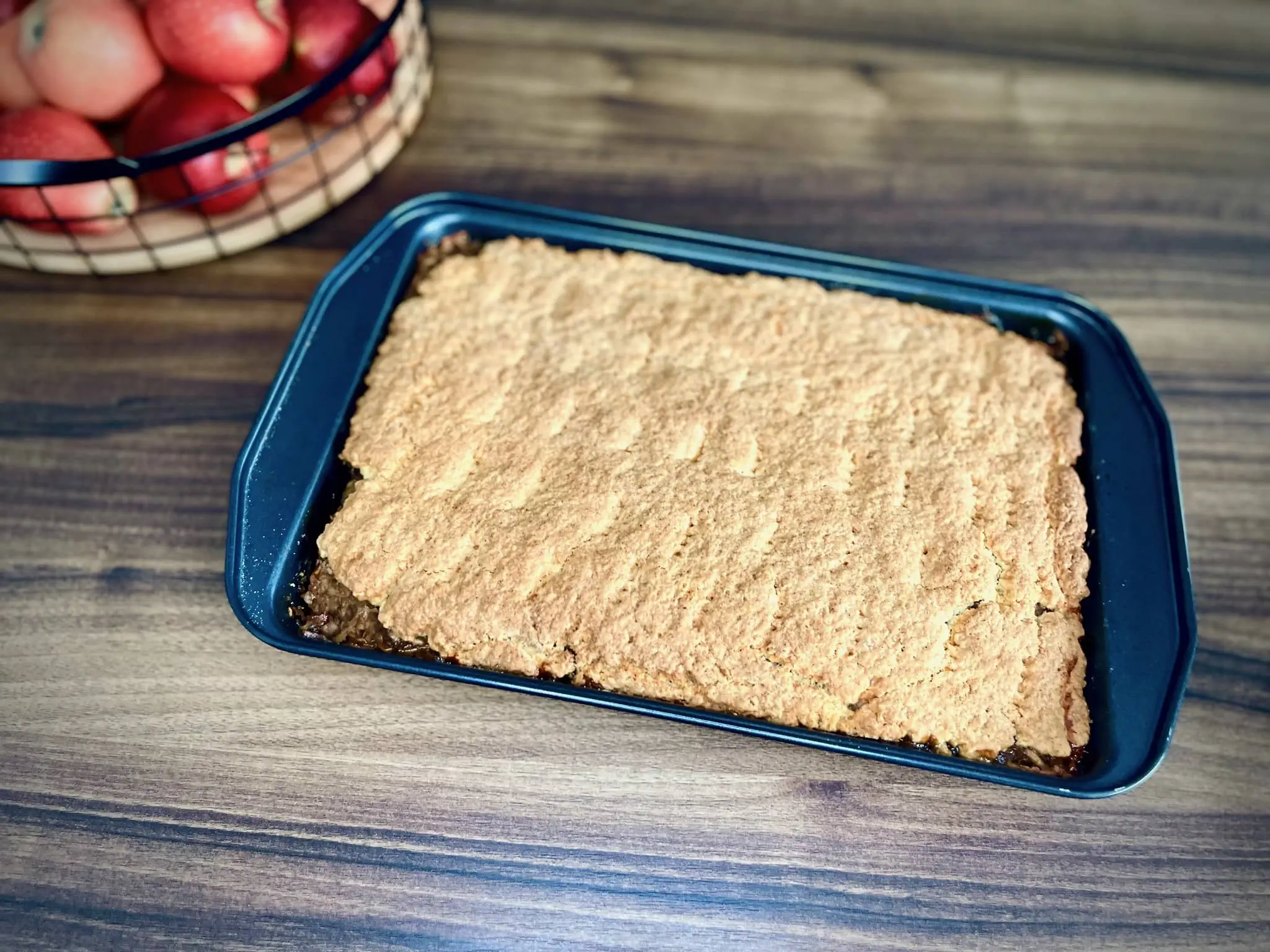 The freshly baked Polish Apple Cake is delicately removed from the oven