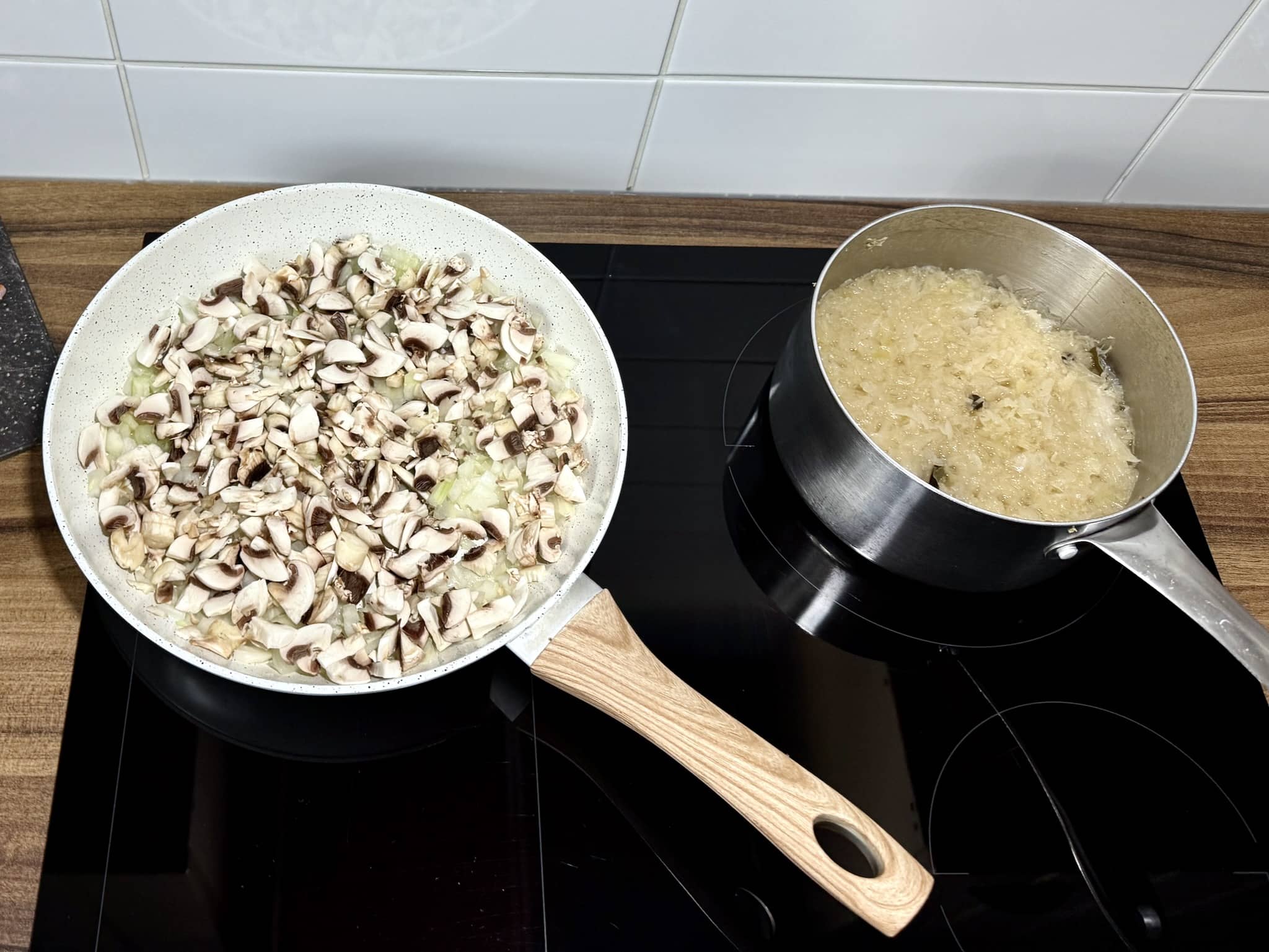 Kapusta kiszona w garnku, cebula i pieczarki na patelni