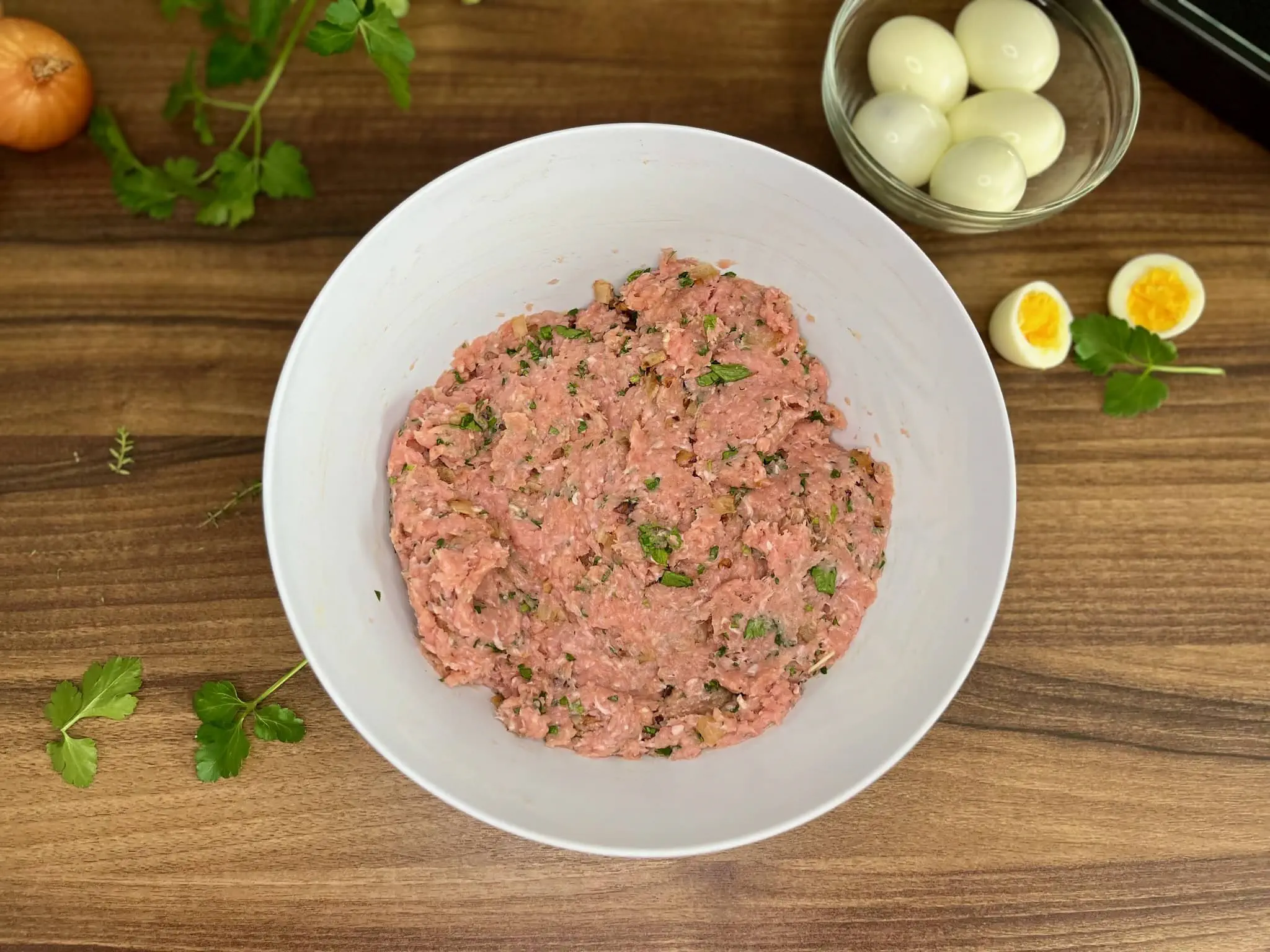 Mixed pork mince with all ingredients in a bowl