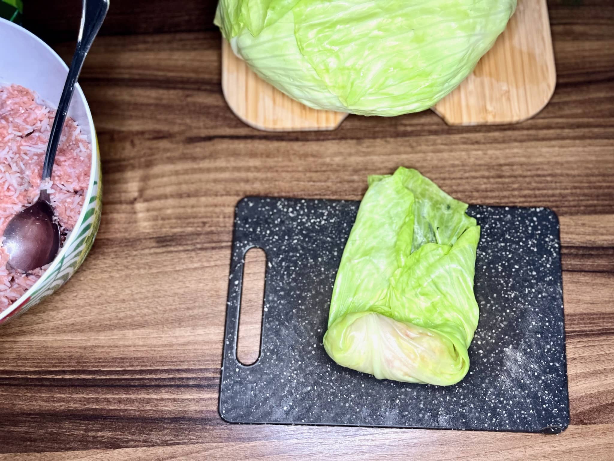 Wrapping cabbage around meat to make Stuffed Cabbage Rolls