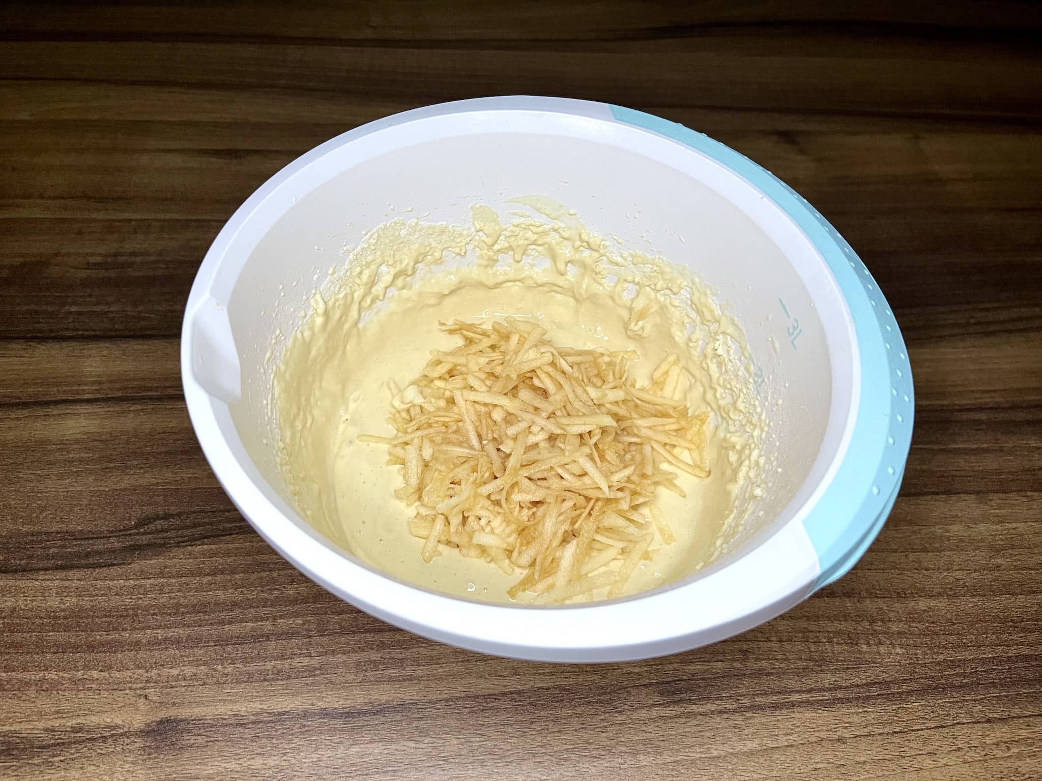 Ciasto na placuszki w misce z dodanymi startymi jabłkami