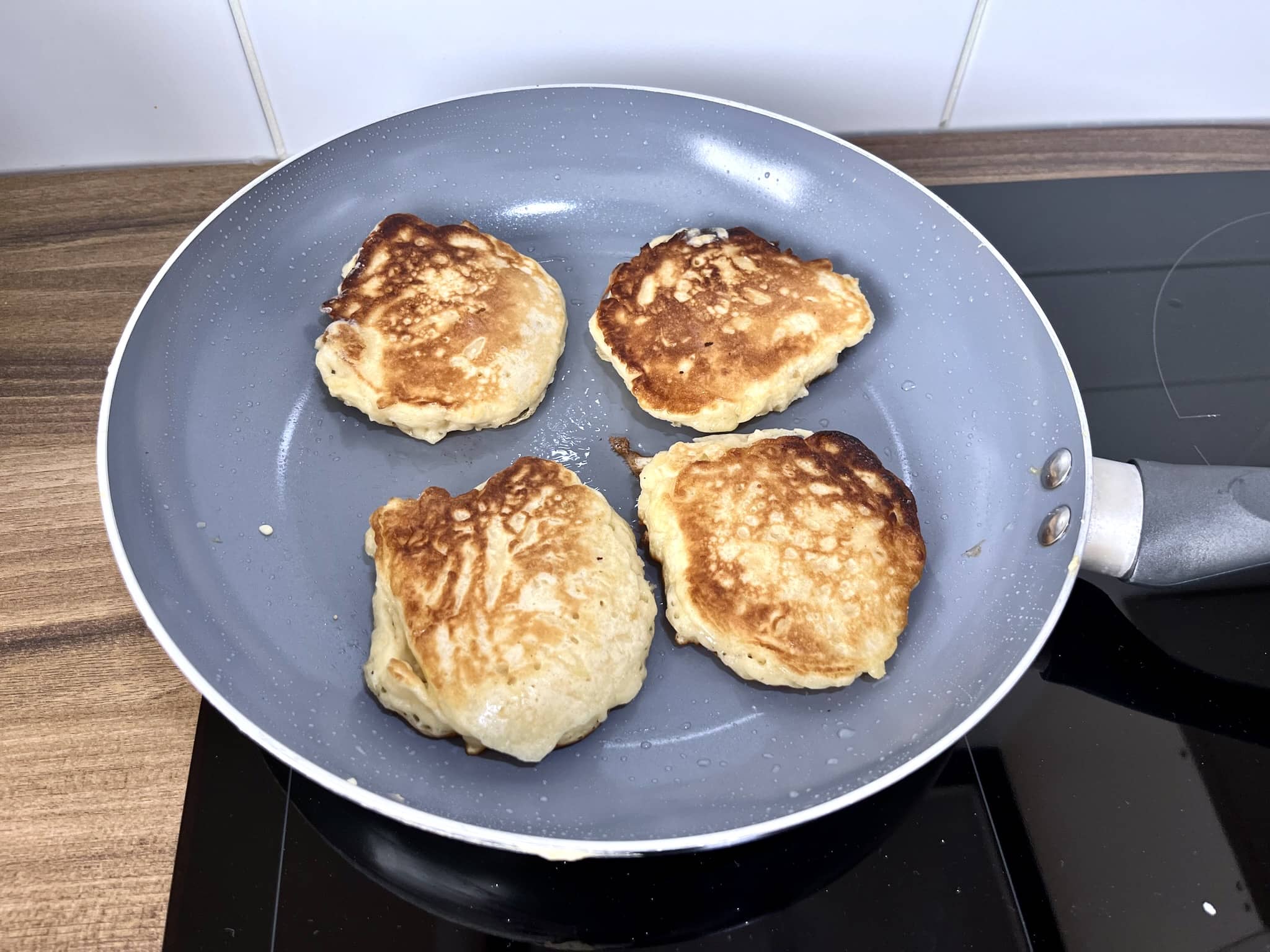 Placuszki z jabłkami smażące się z drugiej strony na patelni