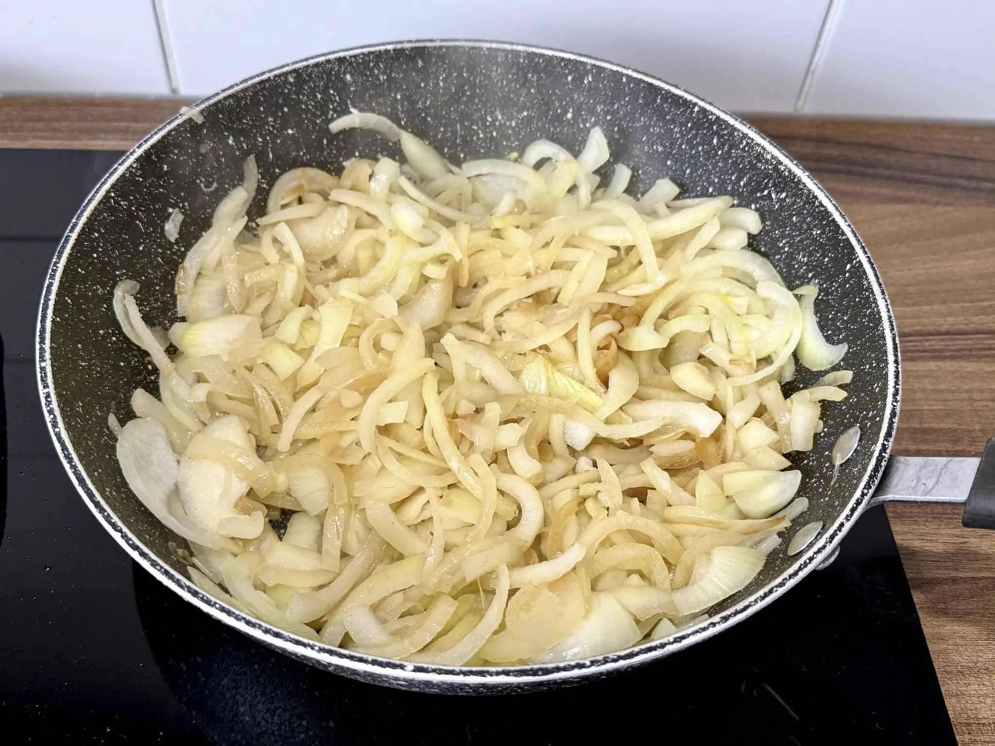 Ładnie usmażona cebula, zrumieniona, na patelni