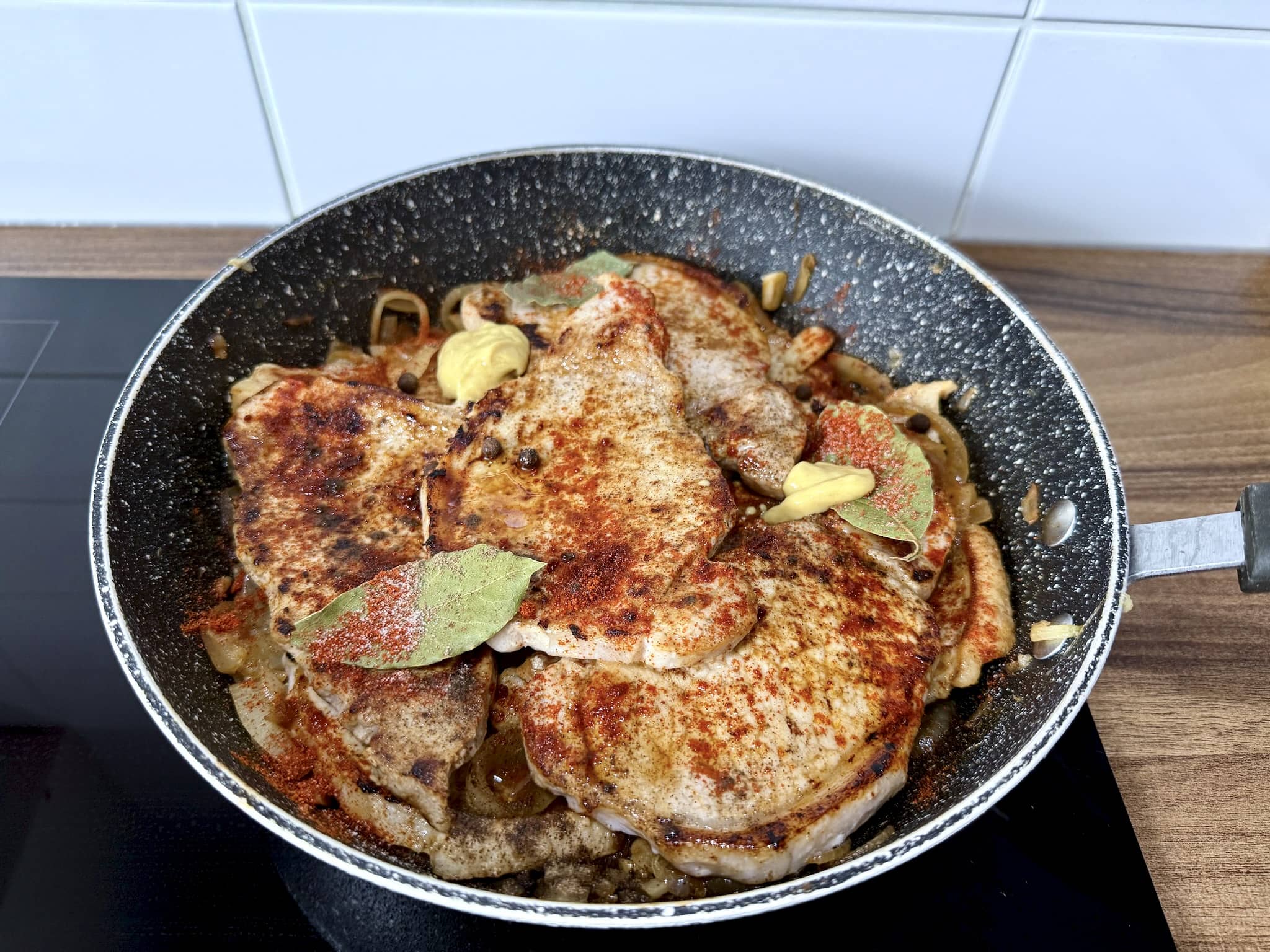Fried pork loins on top of onion sprinkled with spices