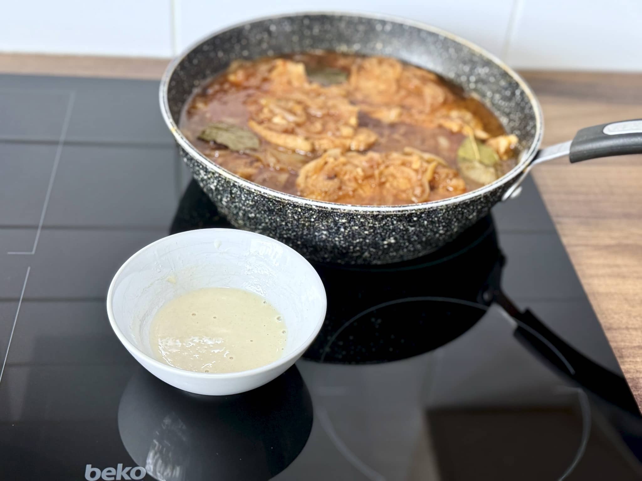 Adding flour to Pork Chops in Onion Sauce in a pan to thicken the sauce