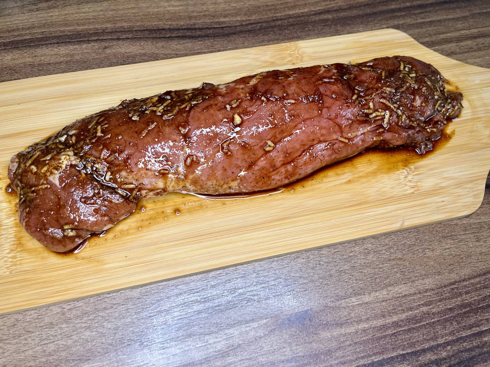 Marinated pork tenderloin on a chopping board