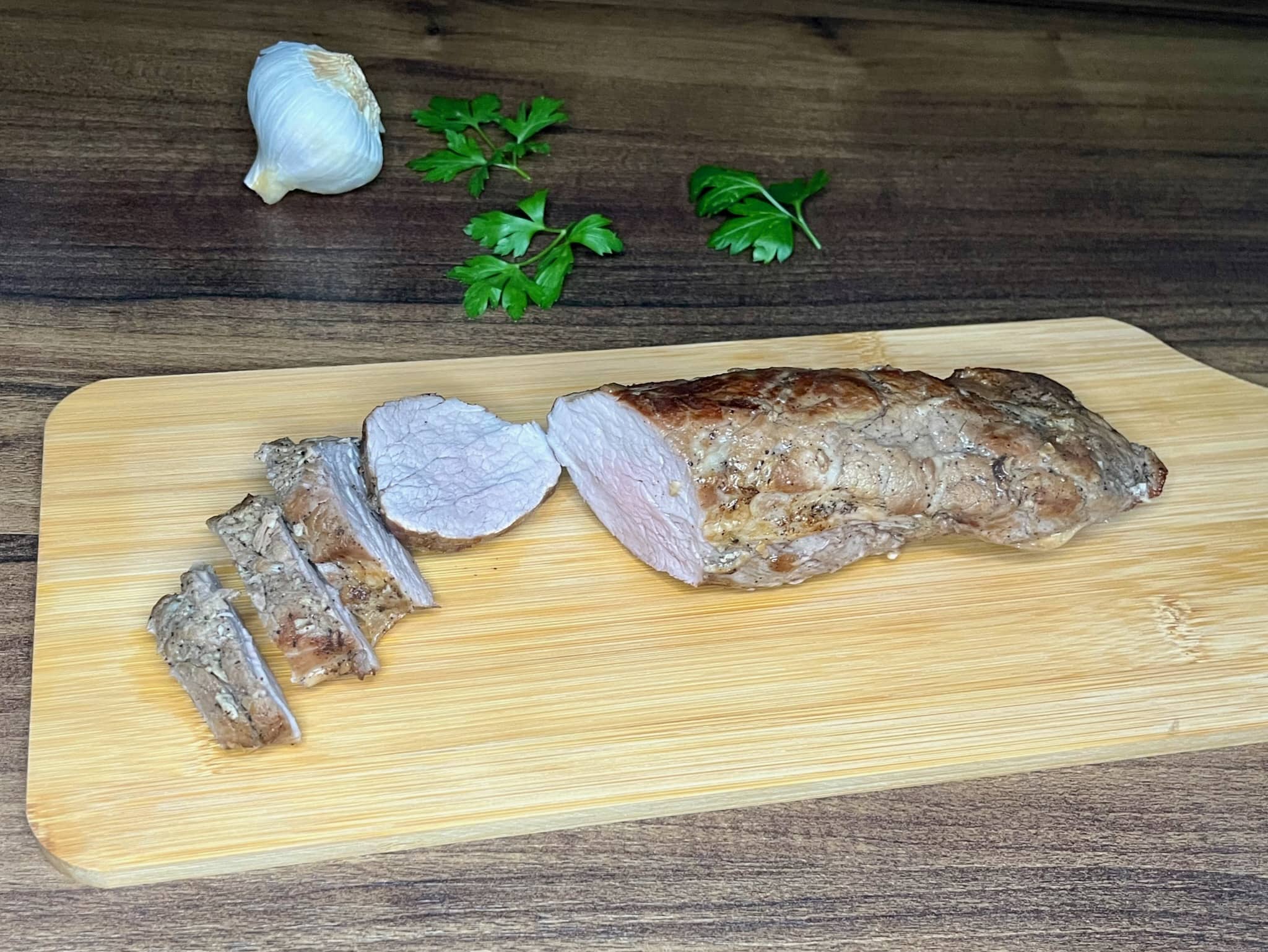 Four slices of pork tenderloin on a chopping board