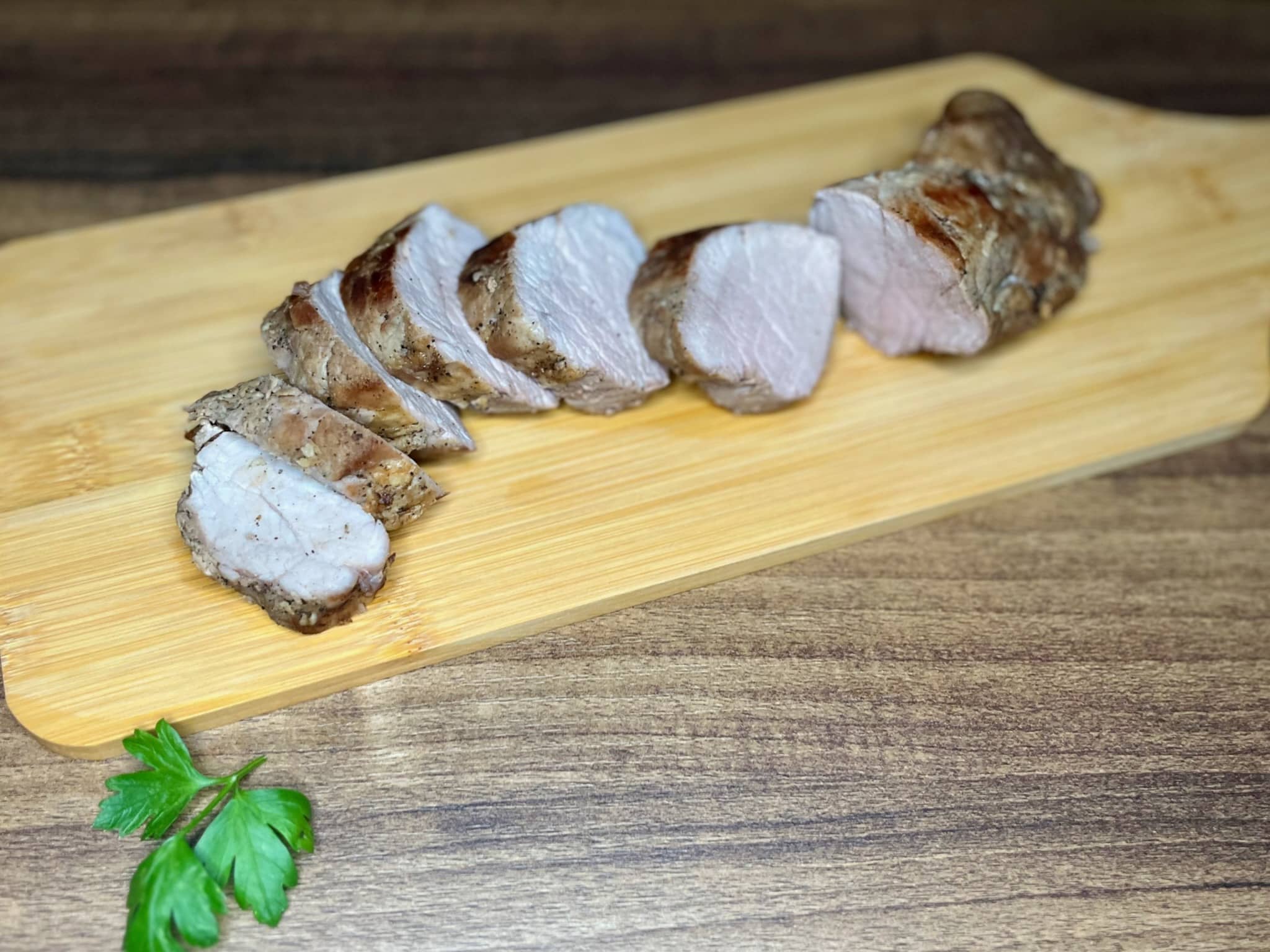 Sliced pork tenderloing on a chopping board