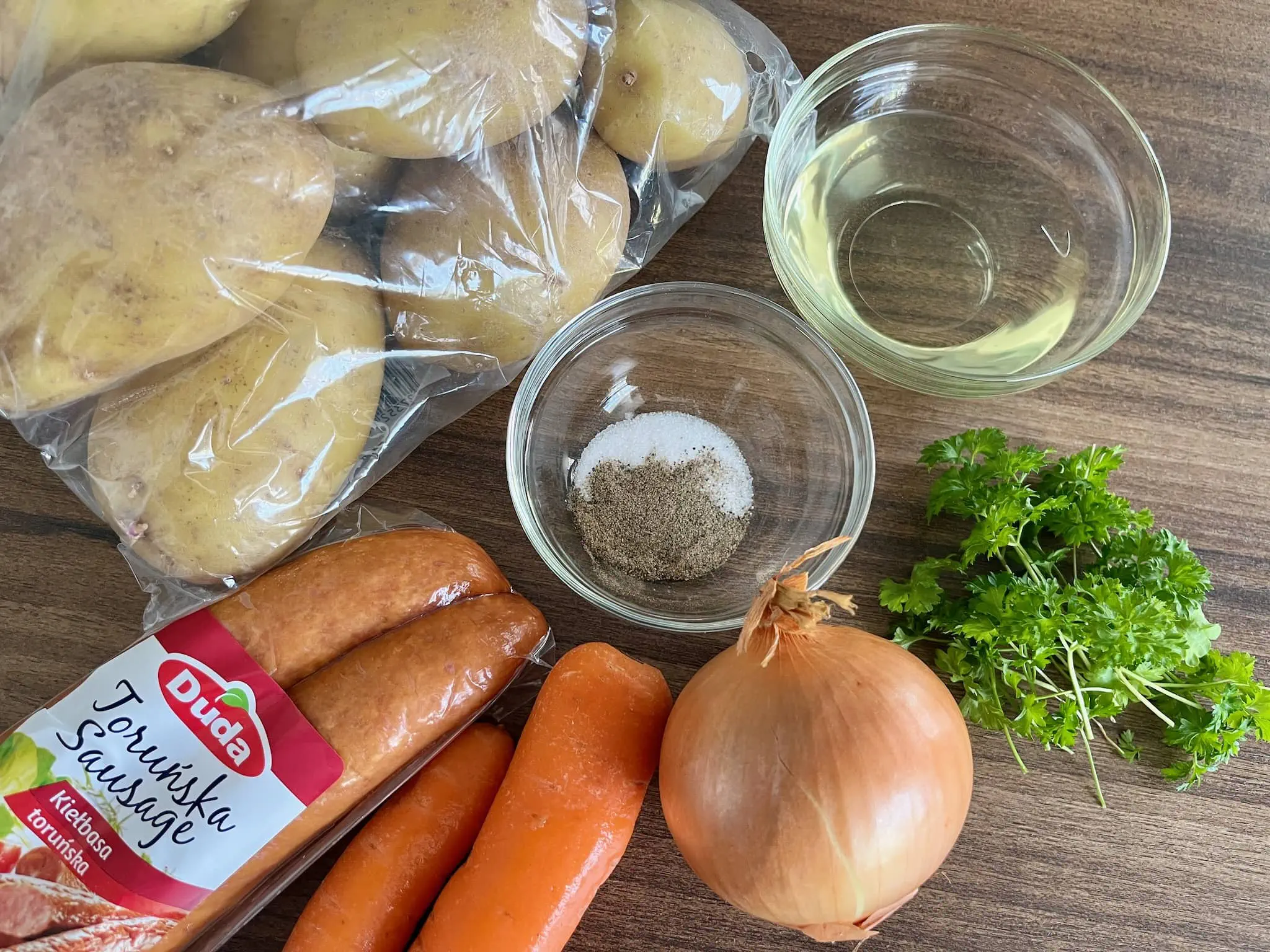 Ziemniaki, marchewka, polska kiełbasa, cebula, pietruszka, sól, pieprz i olej