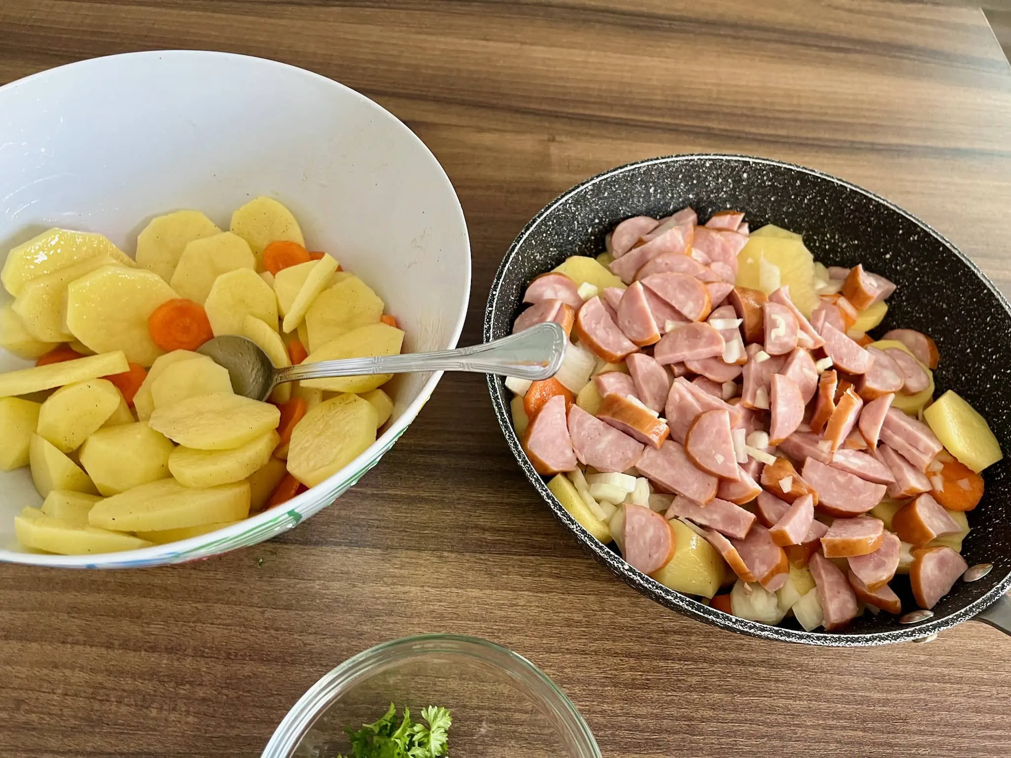 Ziemniaki i marchewka przykryte kiełbasą i cebulą